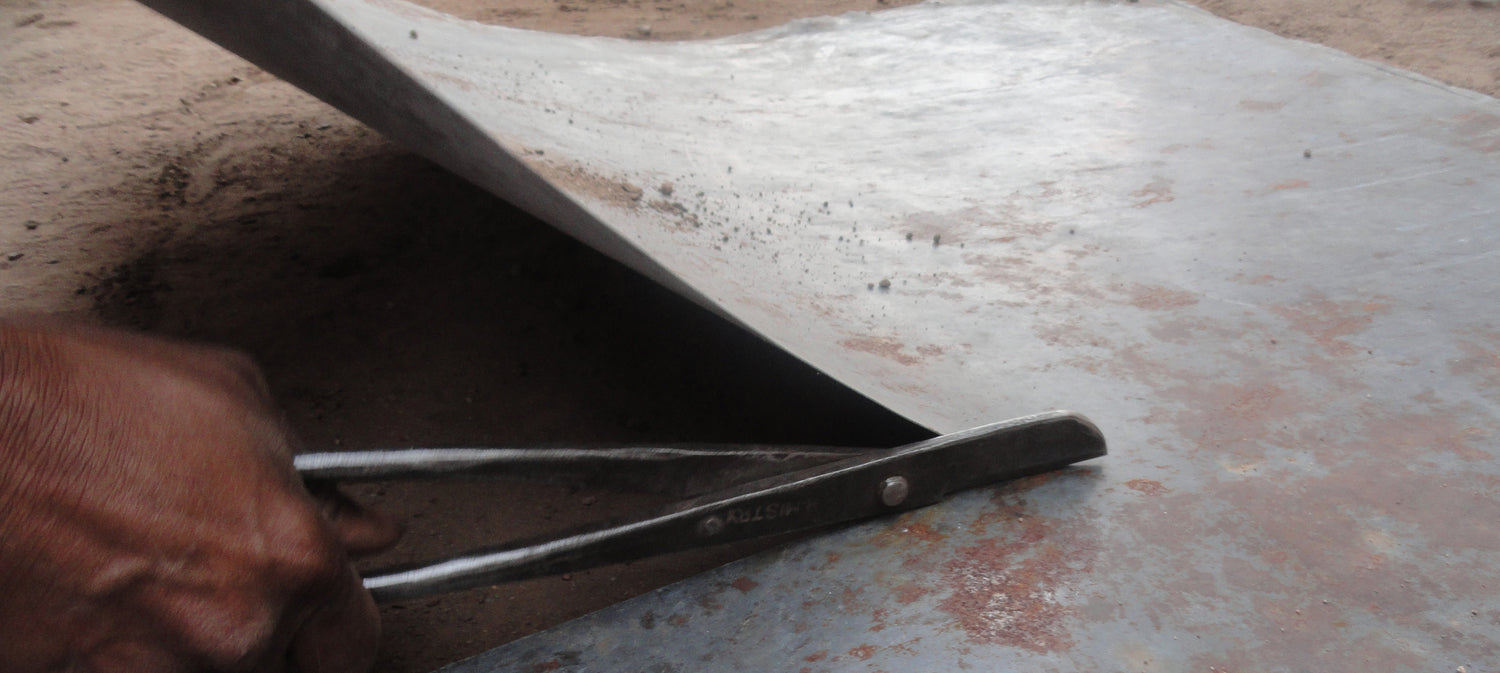Hand holding a tool on a metal surface