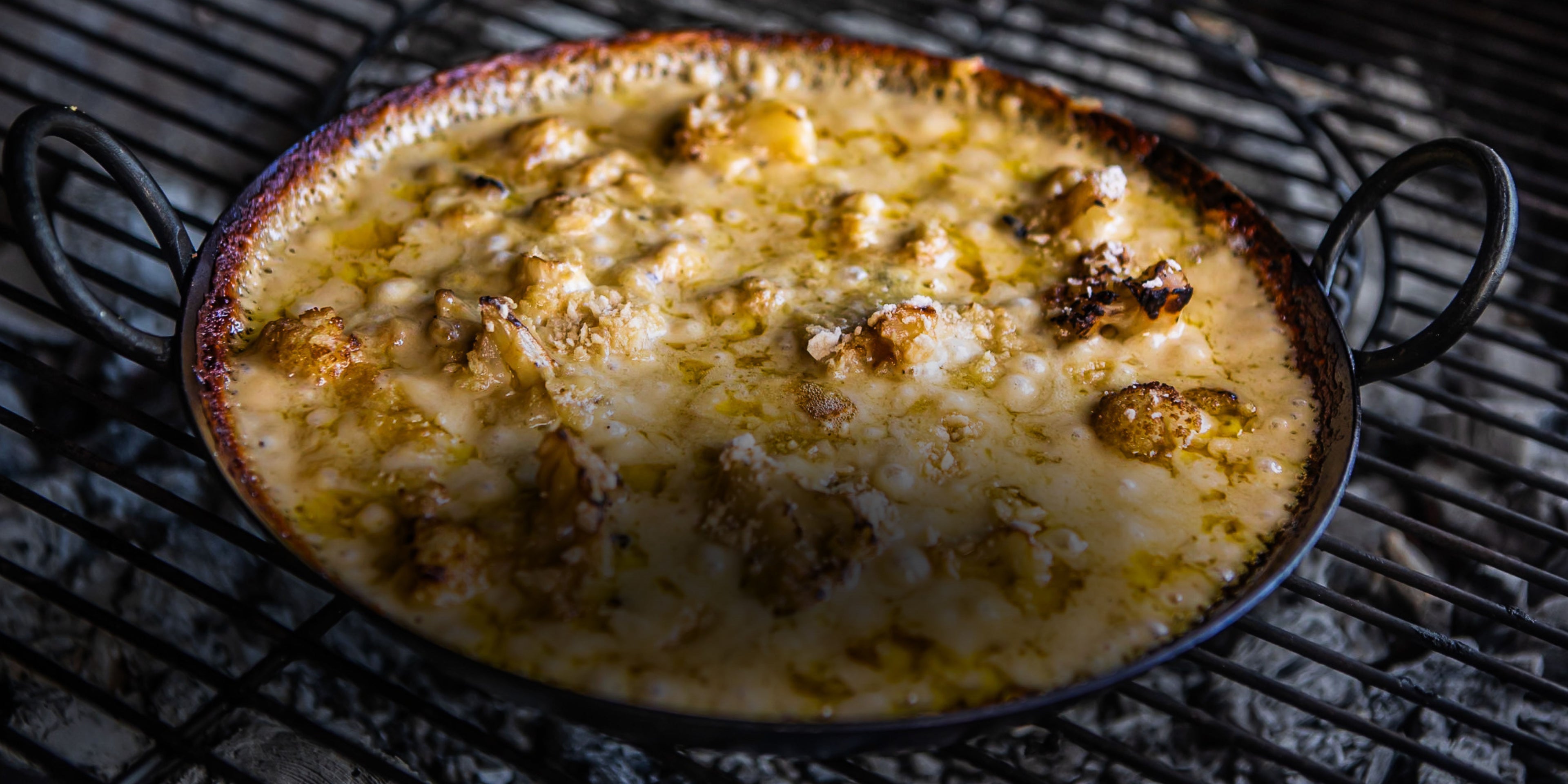 Baked dish with cheese and vegetables in kadai skillet