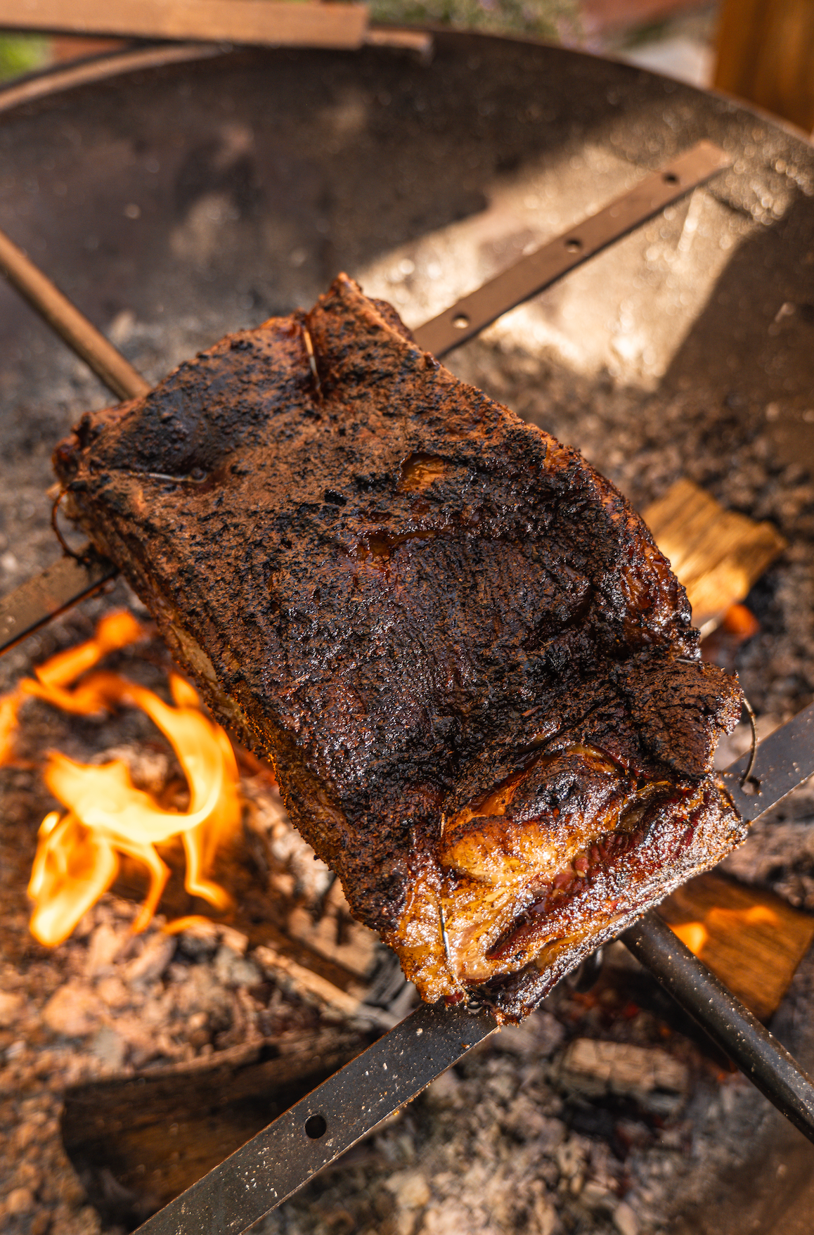 Roasted piece of meat over an open flame on a Kadai grill