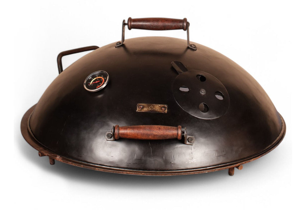 Round metal grill lid with handles on a white background