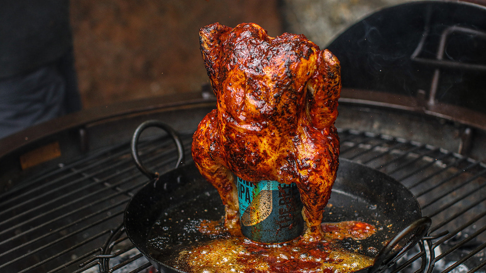 Smoked barbecue chicken on a beer can on a grill