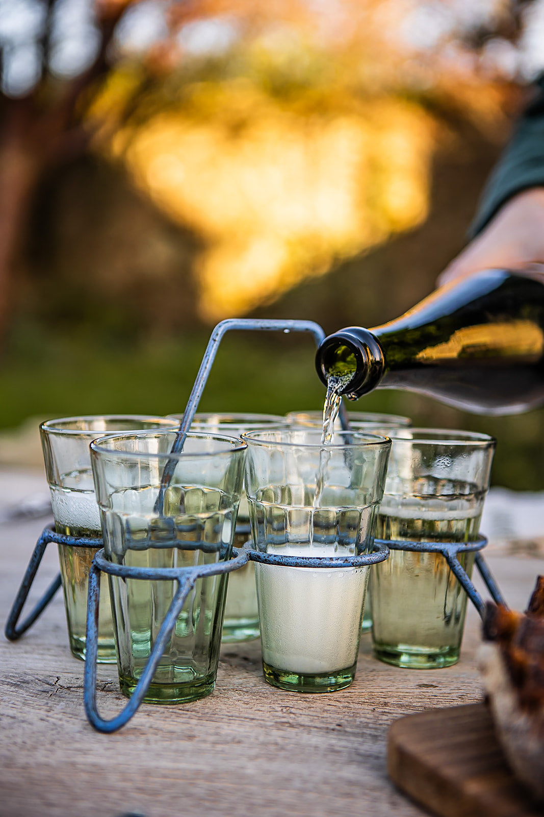 Kadai chai glass set with metal wing holder filled with drinks on rustic outdoor dining table