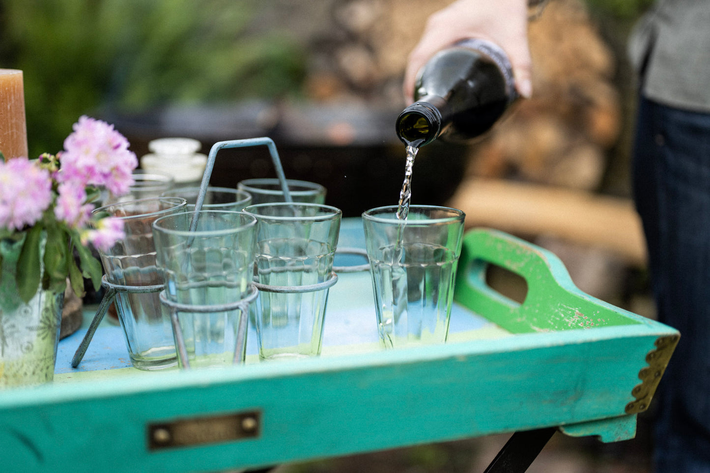 Blue Kadai chai glass set with metal stand on serving tray with wine being poured into glasses