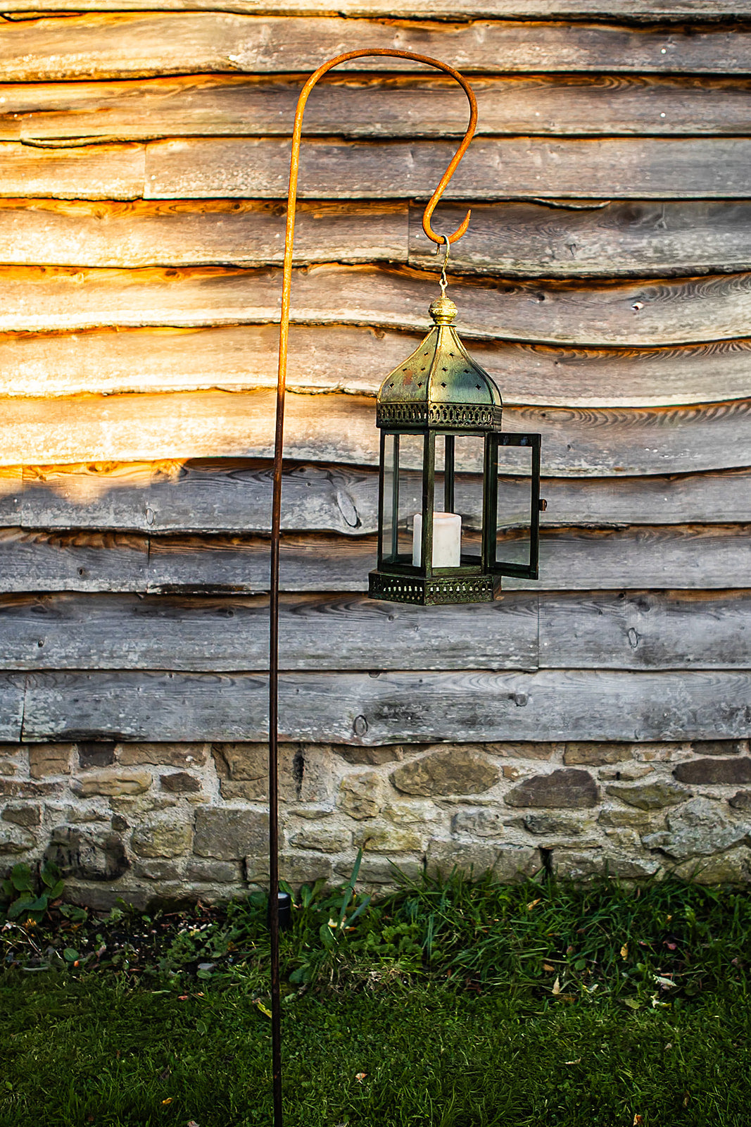 Decorative lantern hanging against a rustic wooden wall.