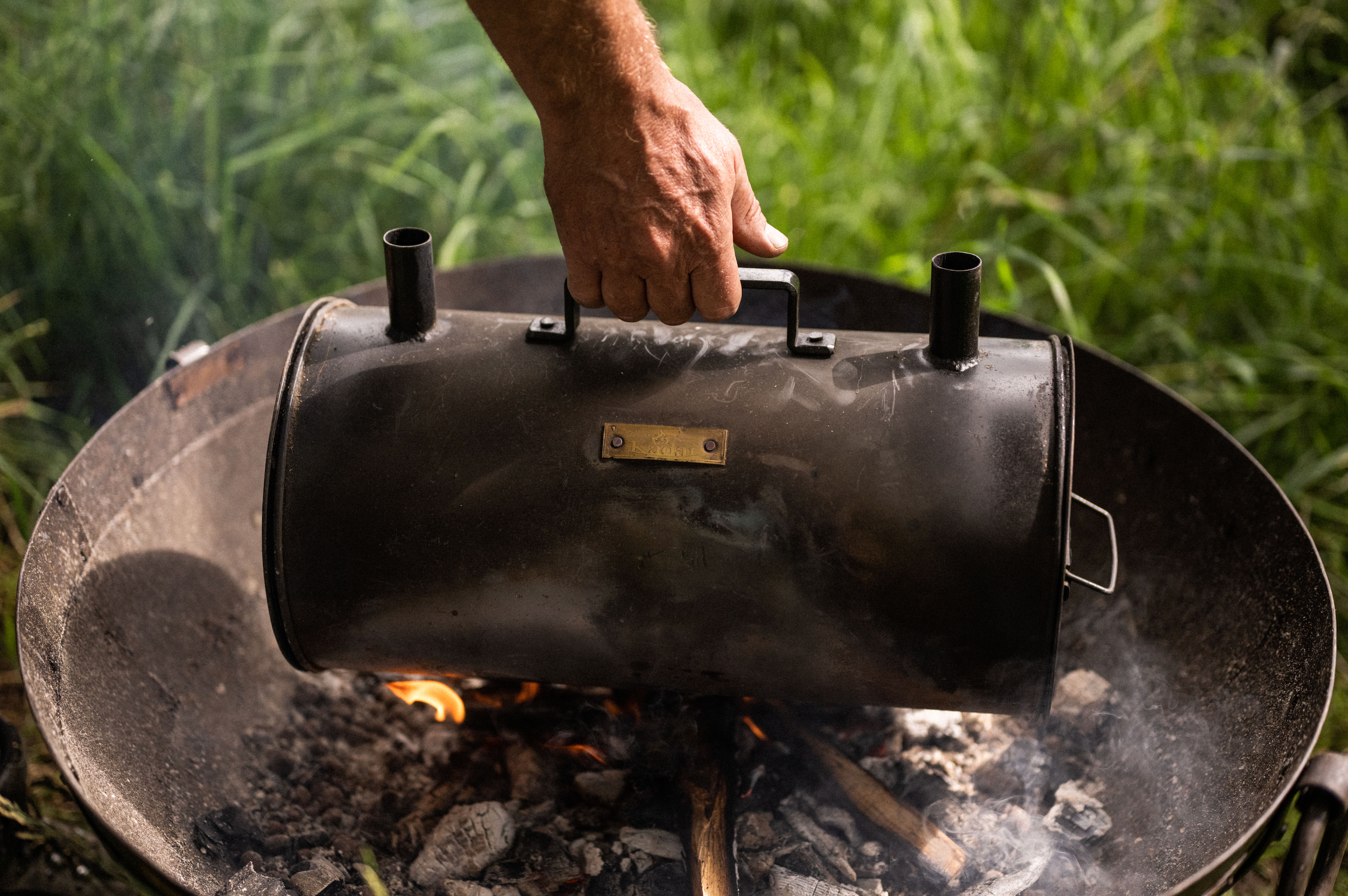 Person using a metal charcoal maker into a firebowl