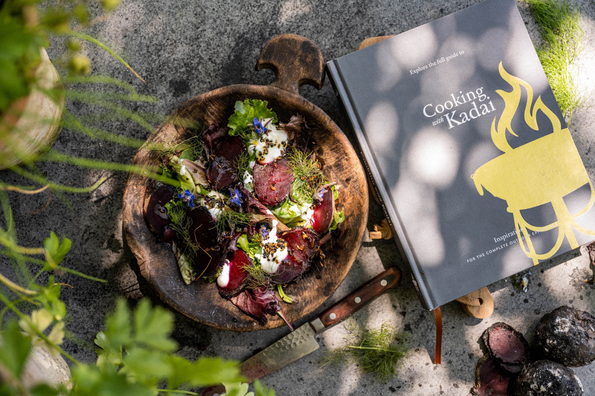 Beetroot salad in a wooden bowl on a slate table top with the Kadai cookbook cooking with Kadai