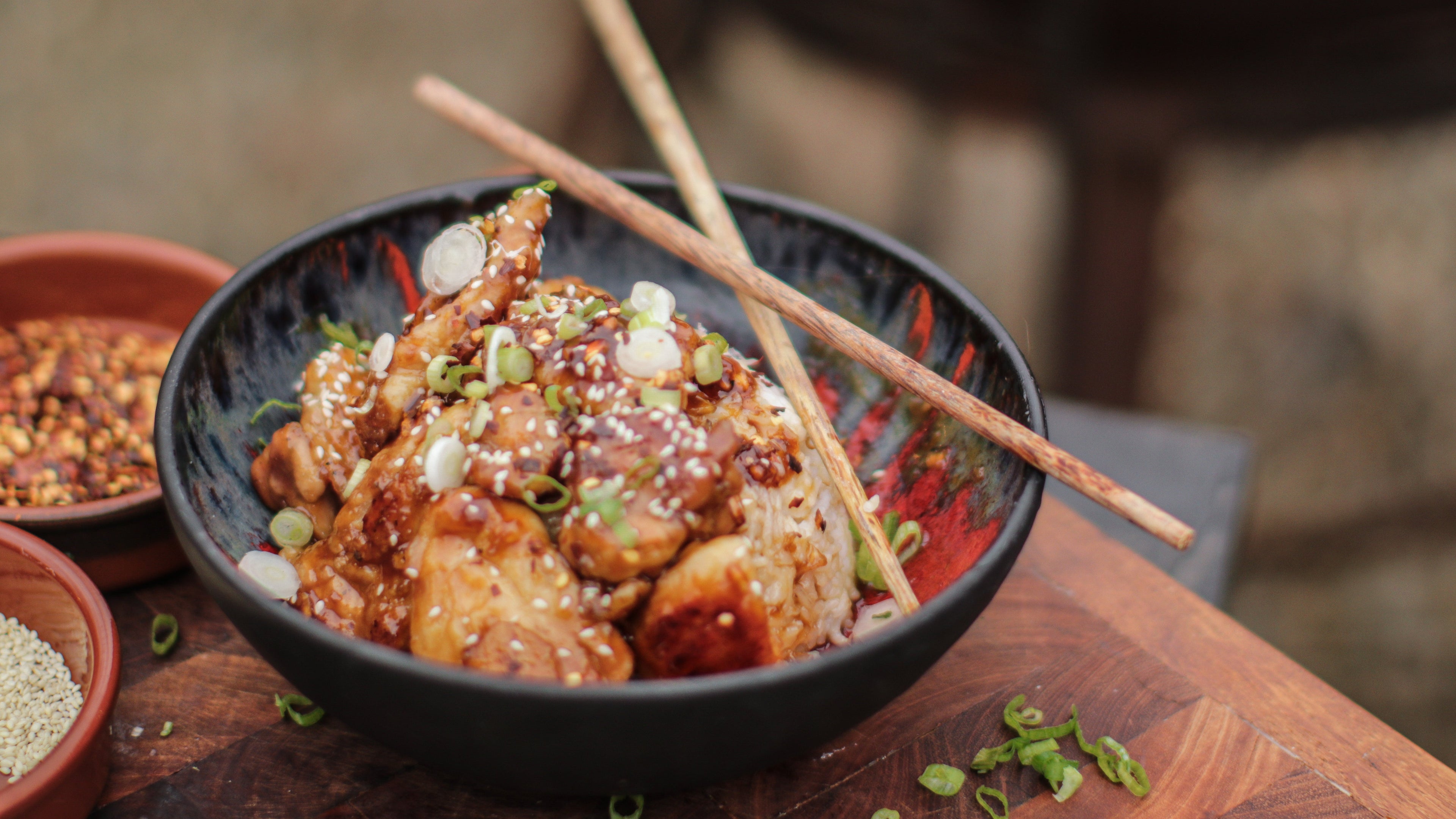 Bowl of food with chopsticks on a wooden table