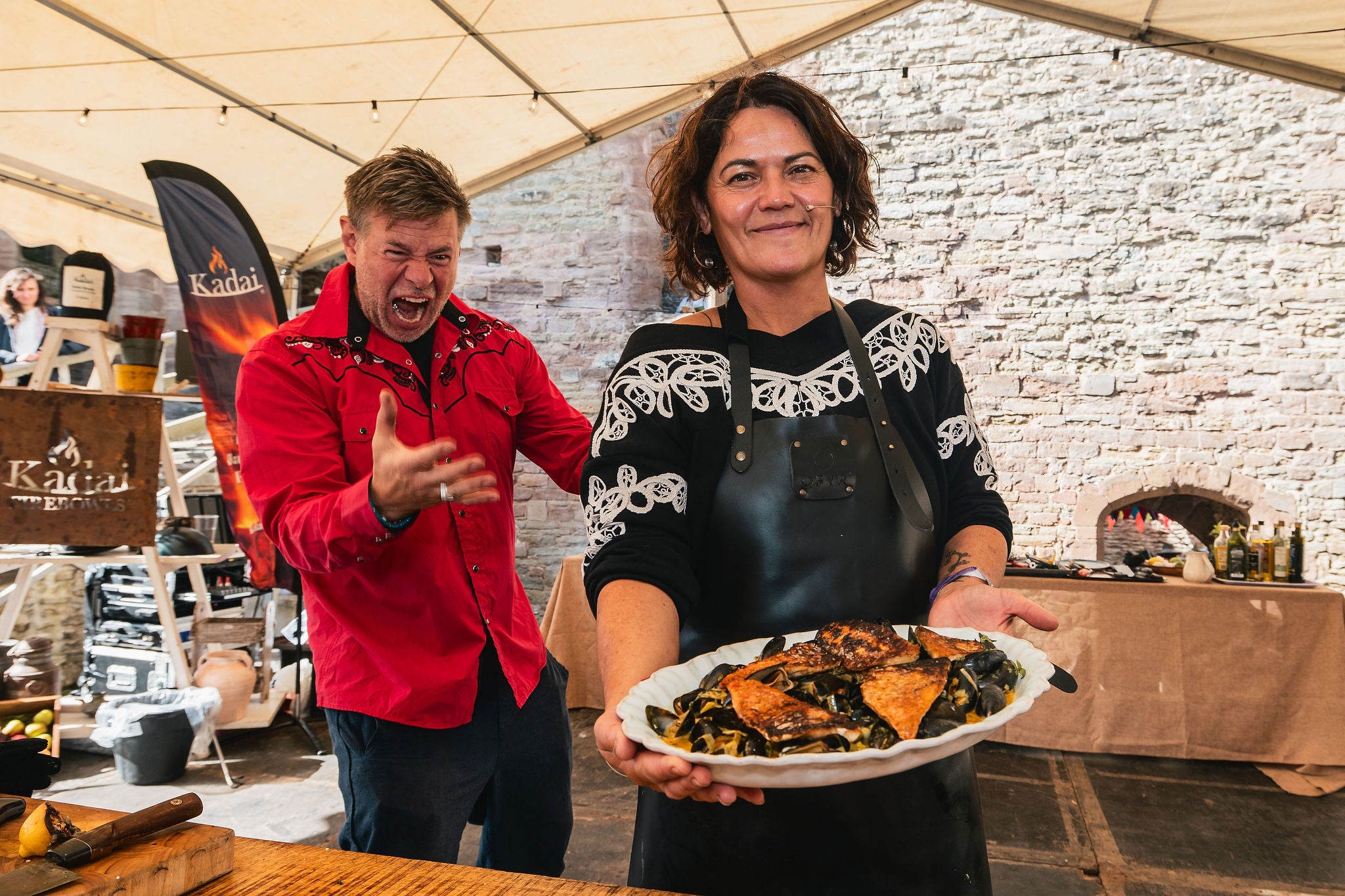 Two people in a casual setting with one holding a plate of food.