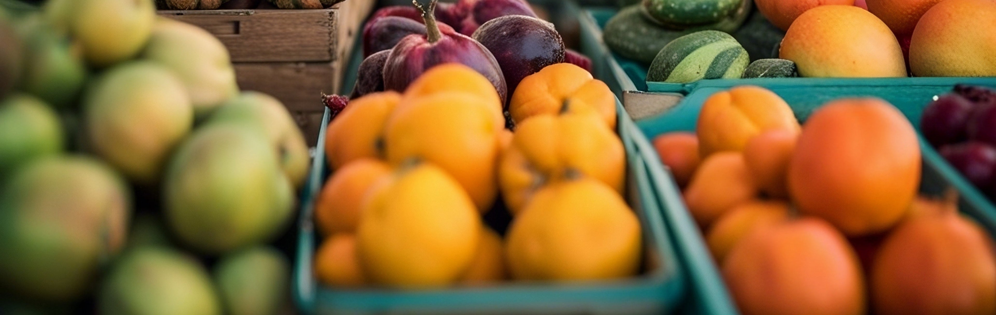 Assorted fruits including oranges, apples, and plums displayed in crates.