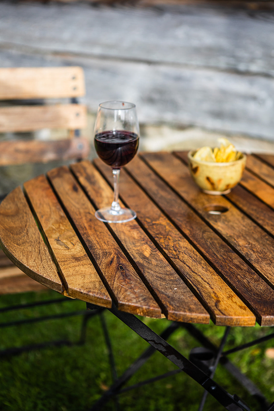 Wine glass with red wine on a wooden table outdoors