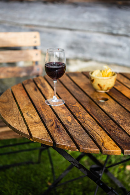 Wine glass with red wine on a wooden table outdoors