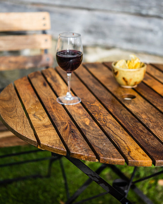 Wine glass with red wine on a wooden garden table outdoors