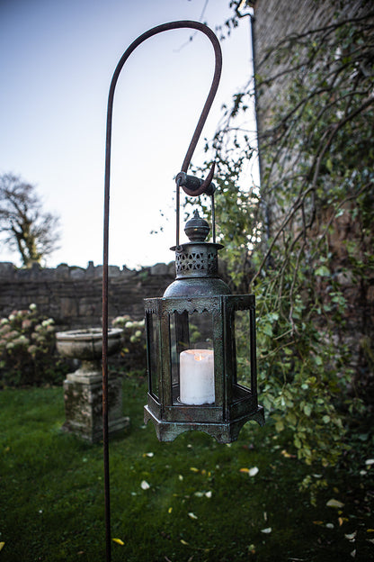 Decorative lantern with a candle in a garden setting