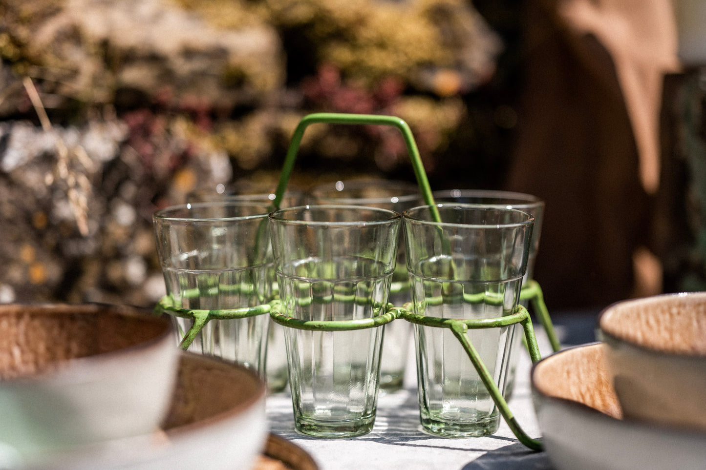 Set of chai glasses in green metal holder on outdoor table ready for serving