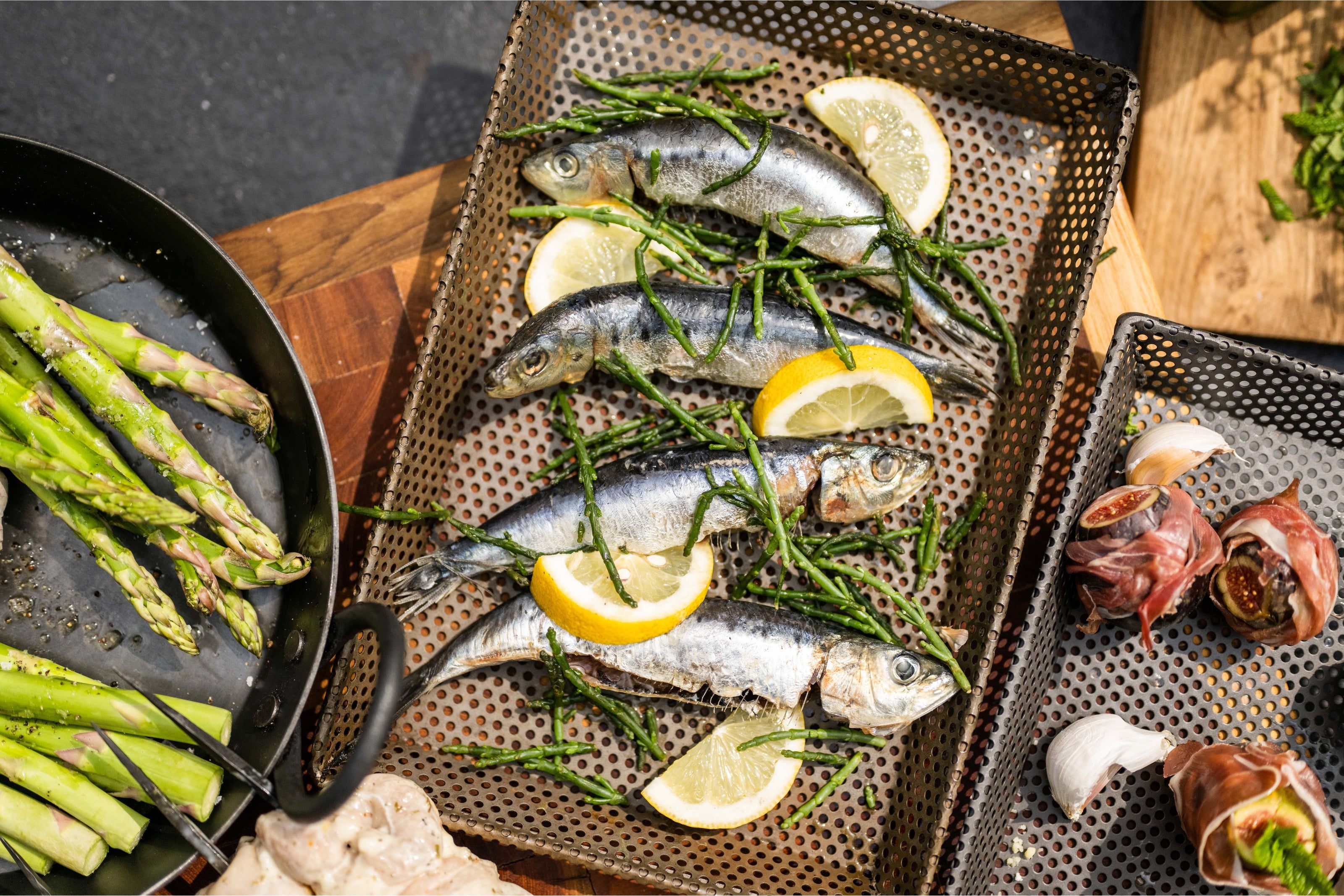 Plated fish with lemon slices and herbs on a wooden surface