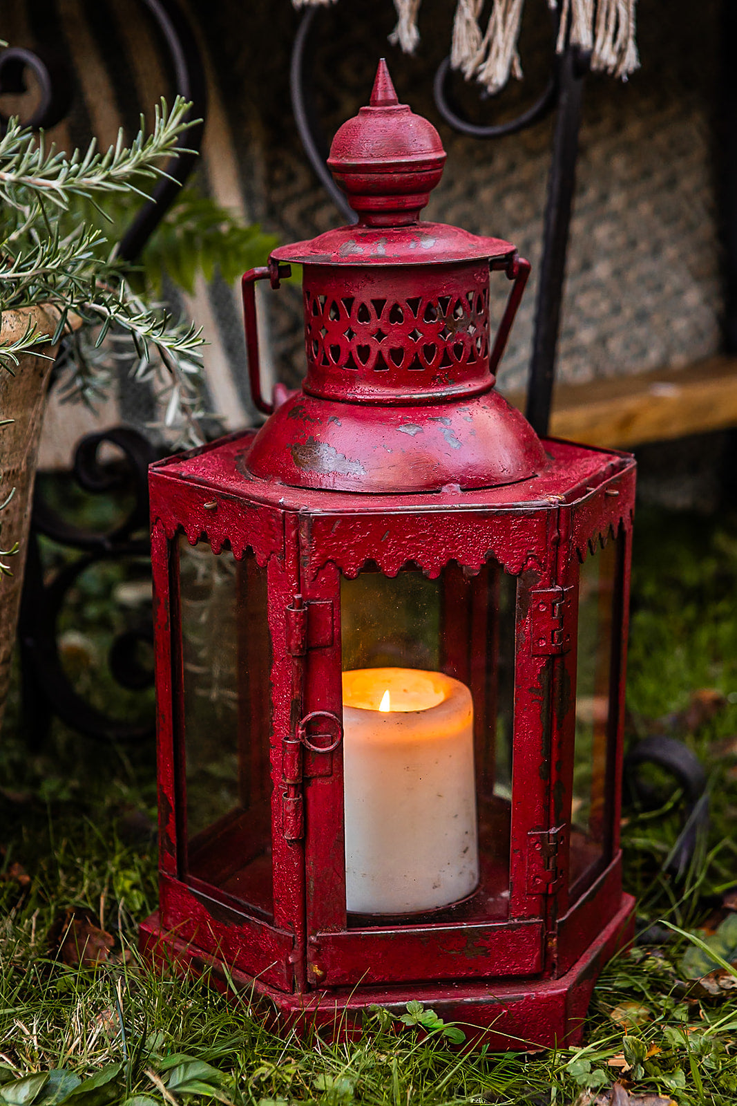 Red lantern with a candle inside on a grassy background