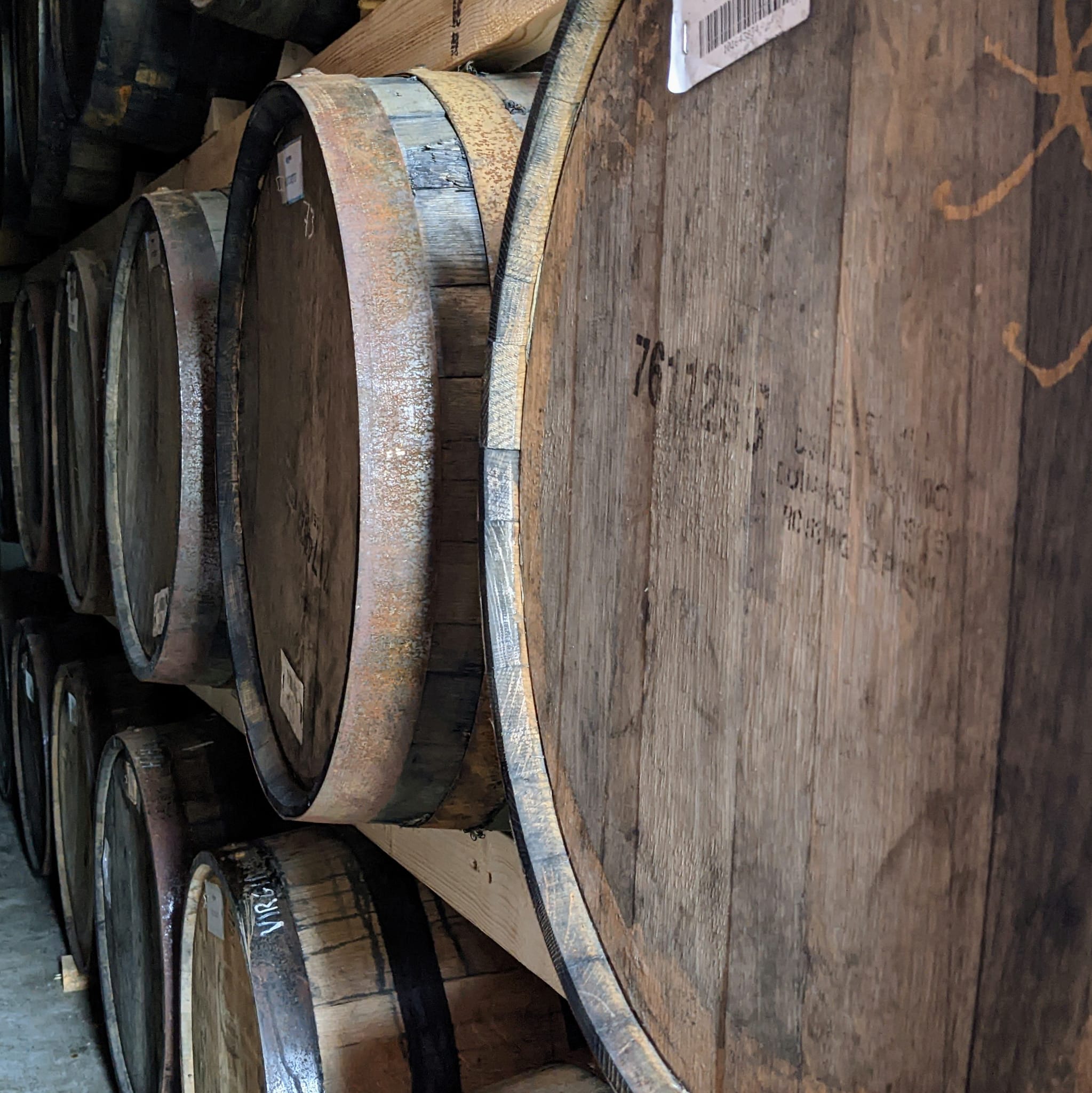 Stack of wooden barrels with visible wear and a label.