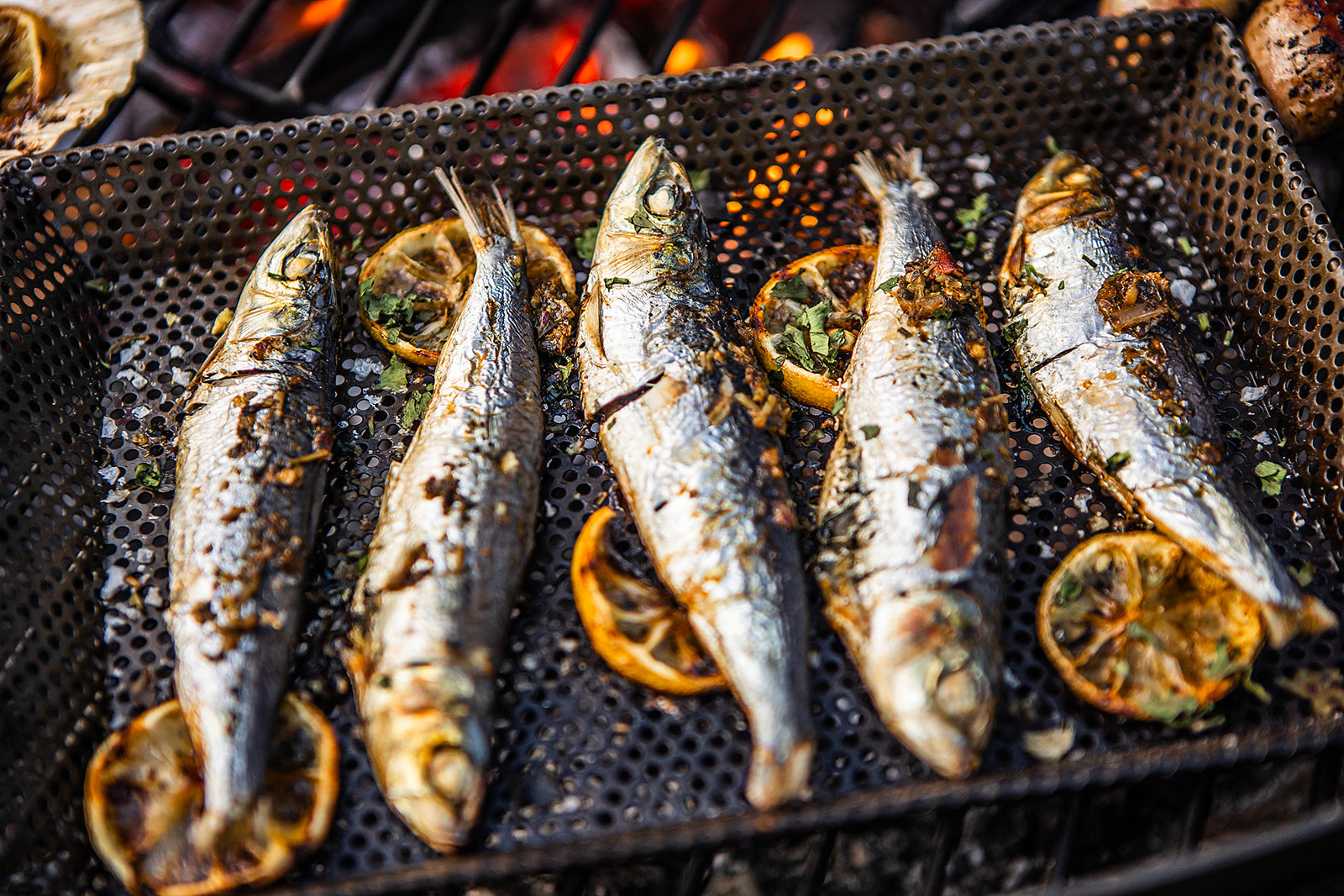 Grilled fish with lemon slices on a barbecue grill
