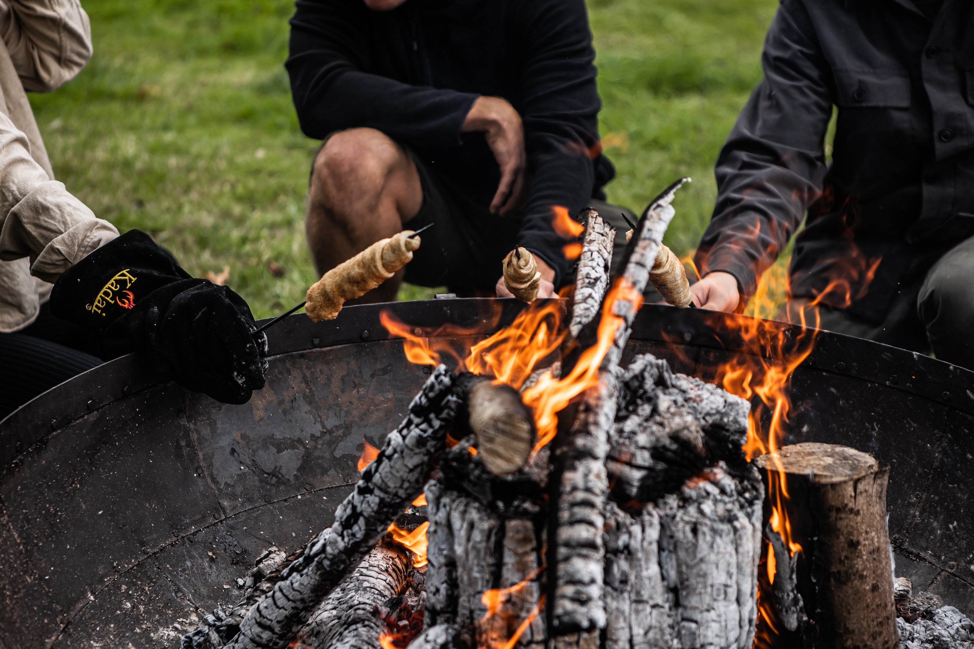 people around kadai firebowl toasting 