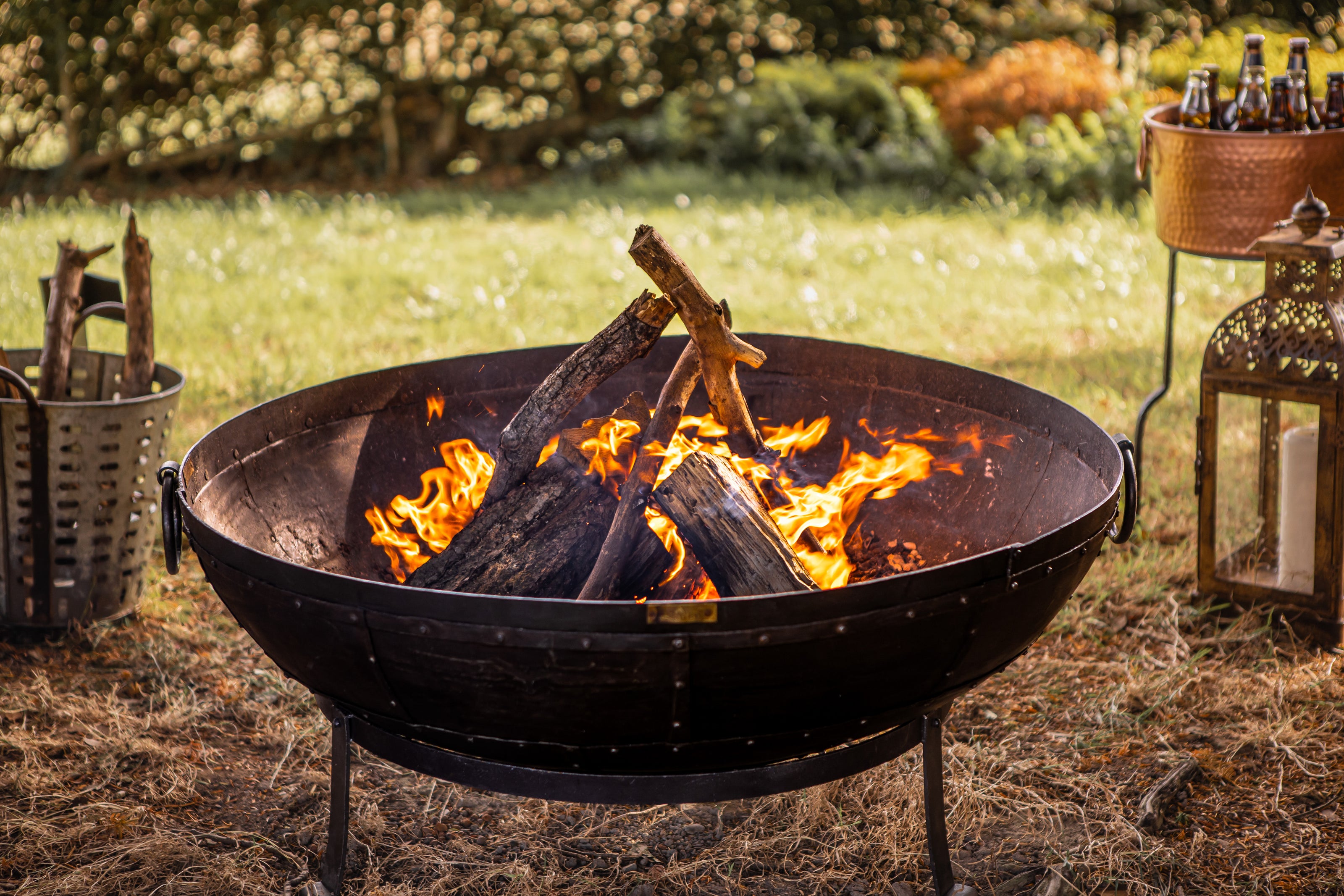 kadai Fire pit with burning wood in a garden setting