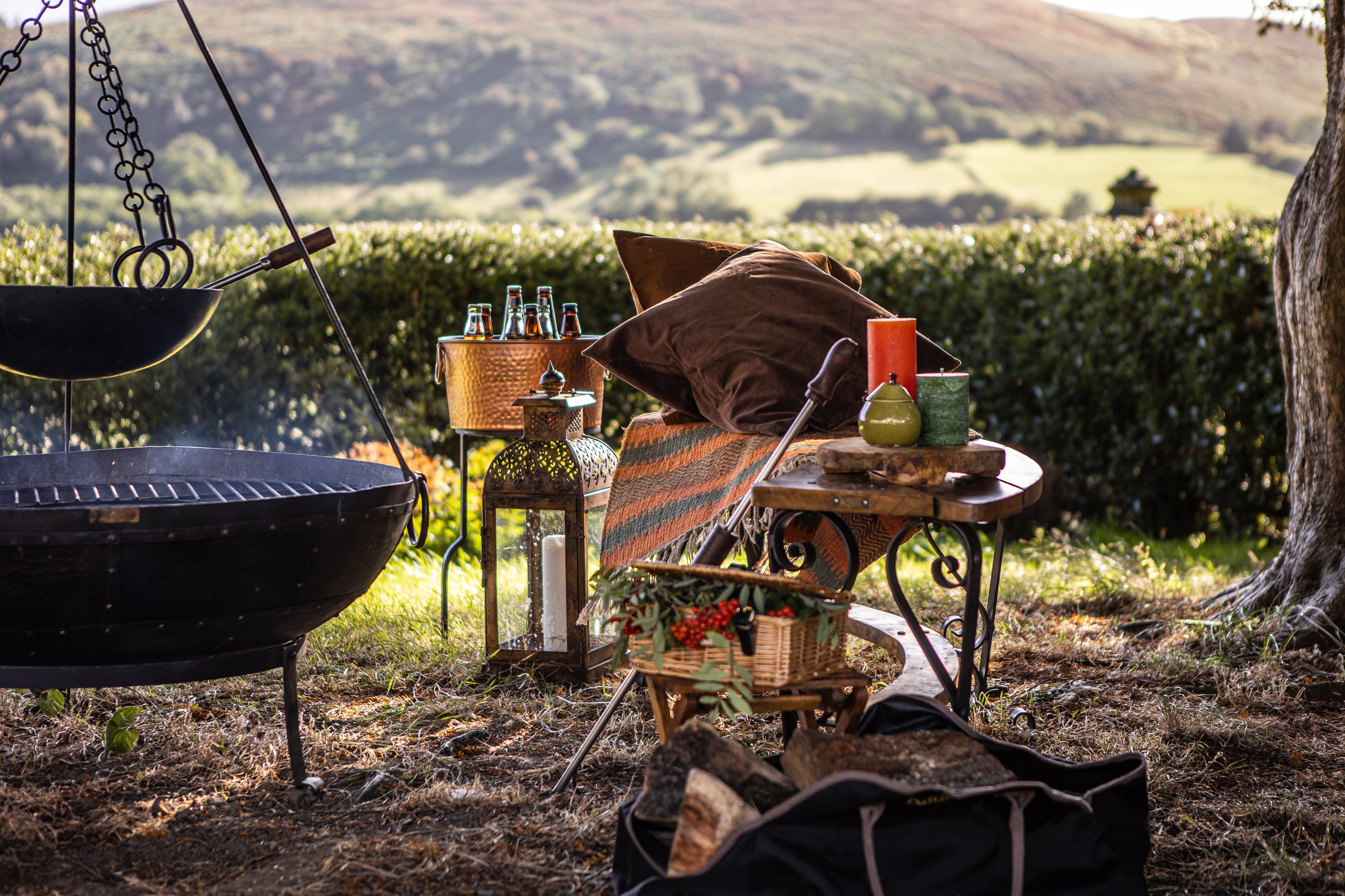 Outdoor setting with a grill, drinks, and a scenic background