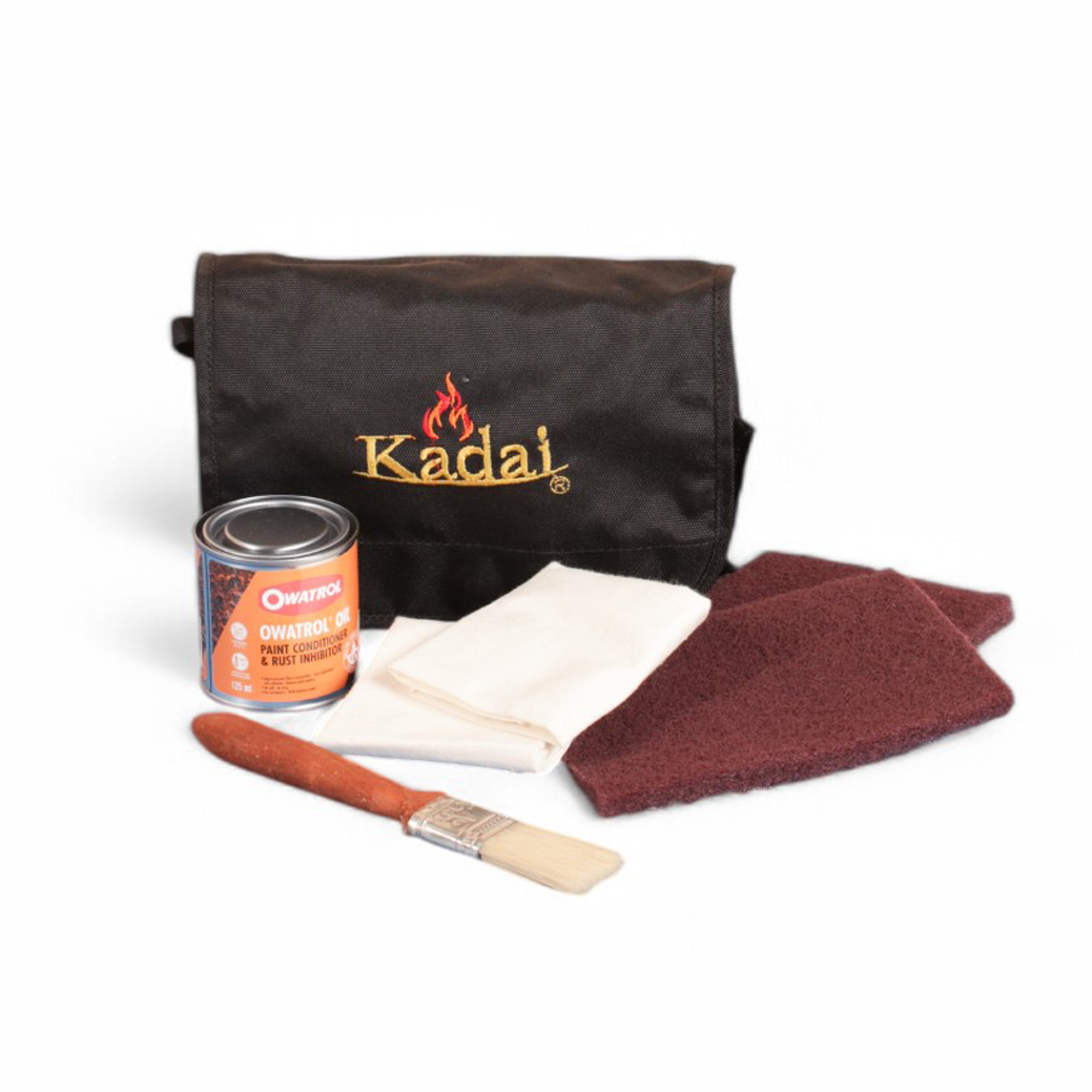 Kadal care kit with black pouch, jar of owatrol oil, cloth, scotch pads and brush on a white background