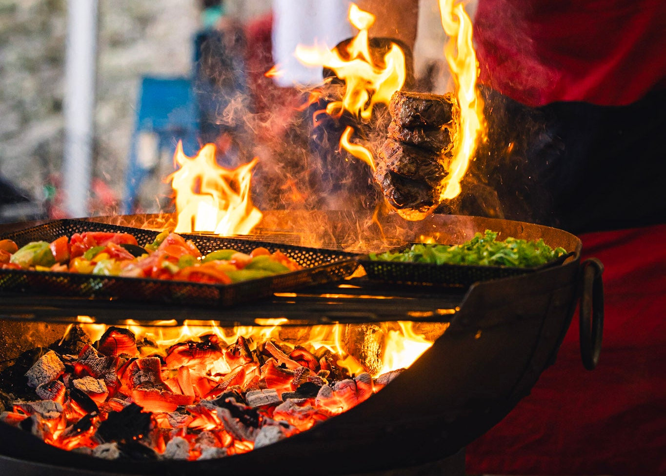 BBQ with hot charcoal food on the grill trays and steaks on fire 