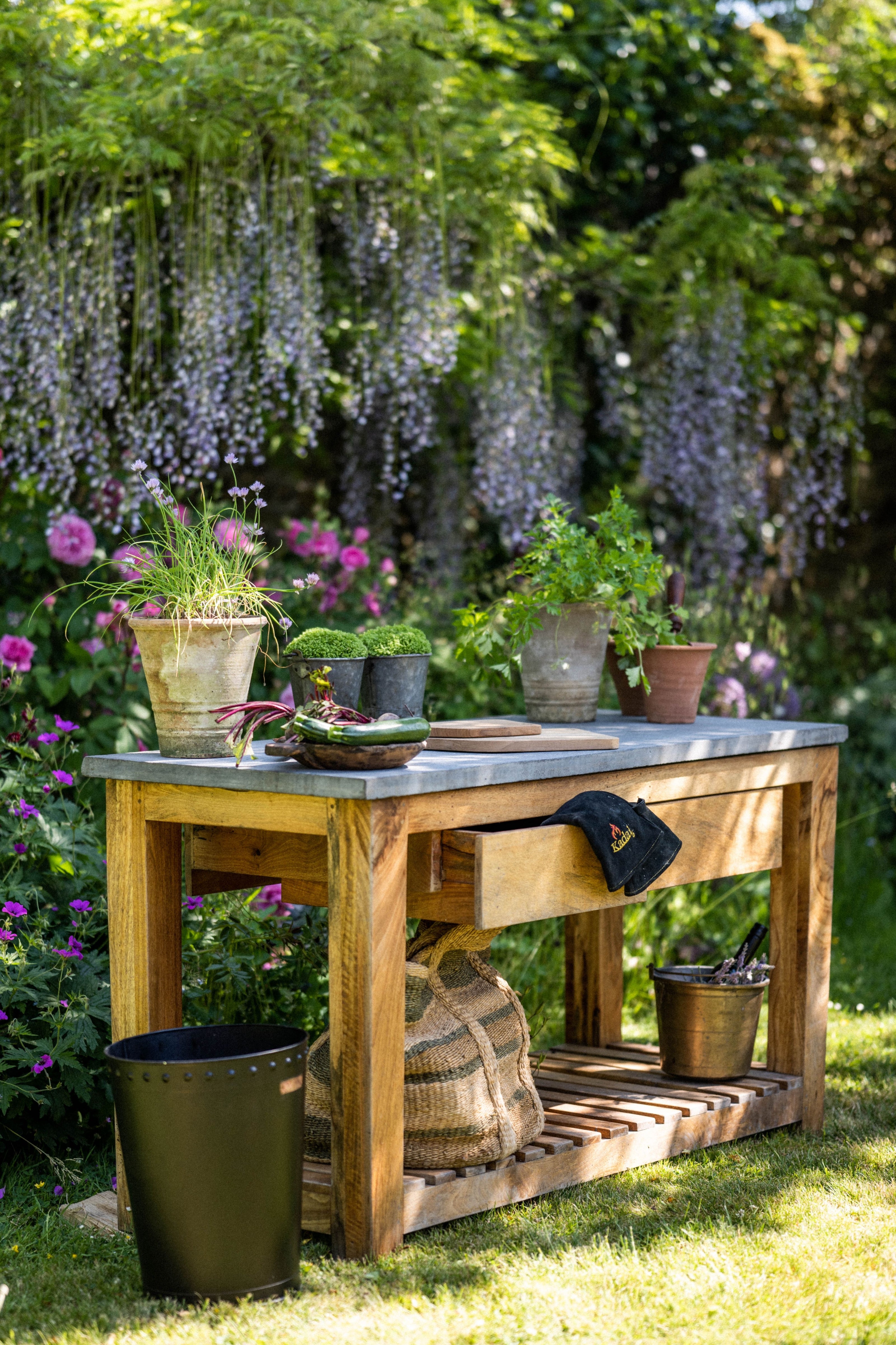 Wooden garden workbench with plants and tools in a lush garden setting