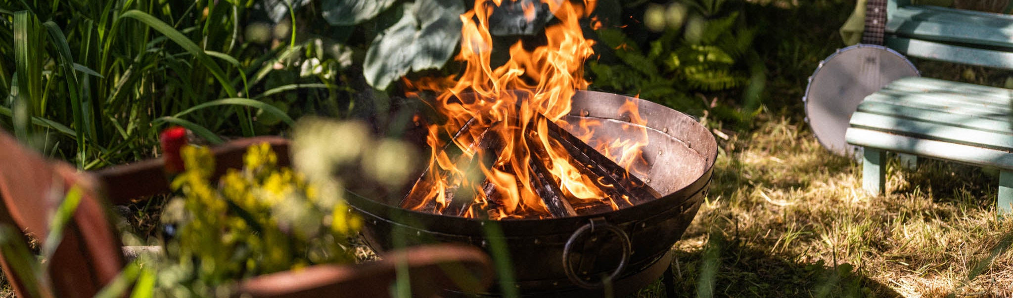 Kadai outdoor fire pit in a garden setting with seating and greenery.