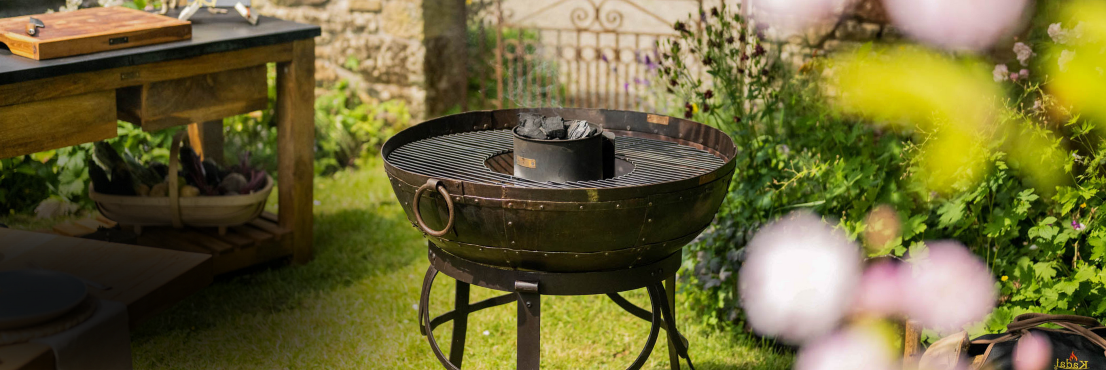 BBQ Fire pit on grass with charcoal burning in a garden setting