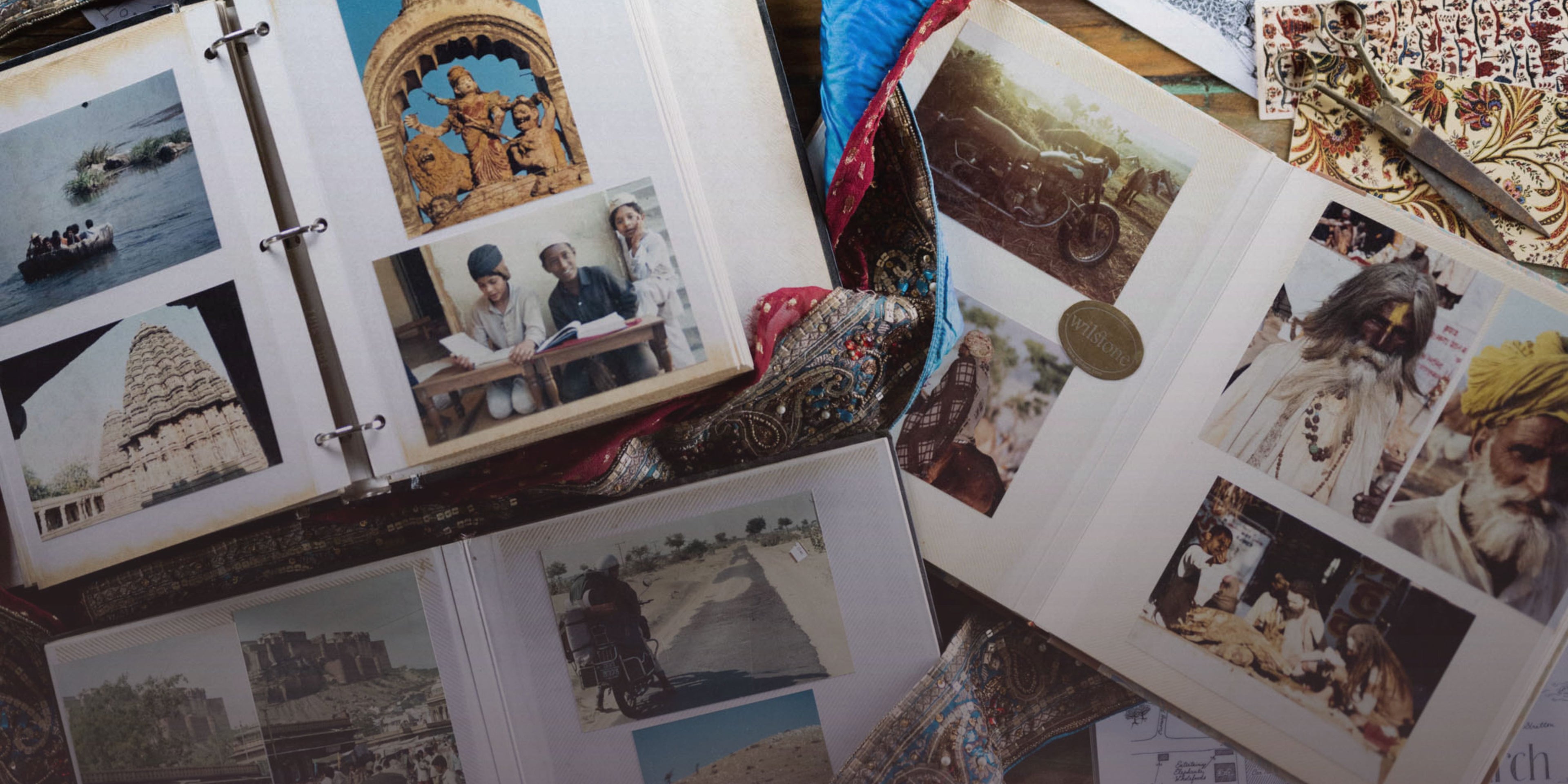 Open photo album with travel photos and postcards on a wooden surface