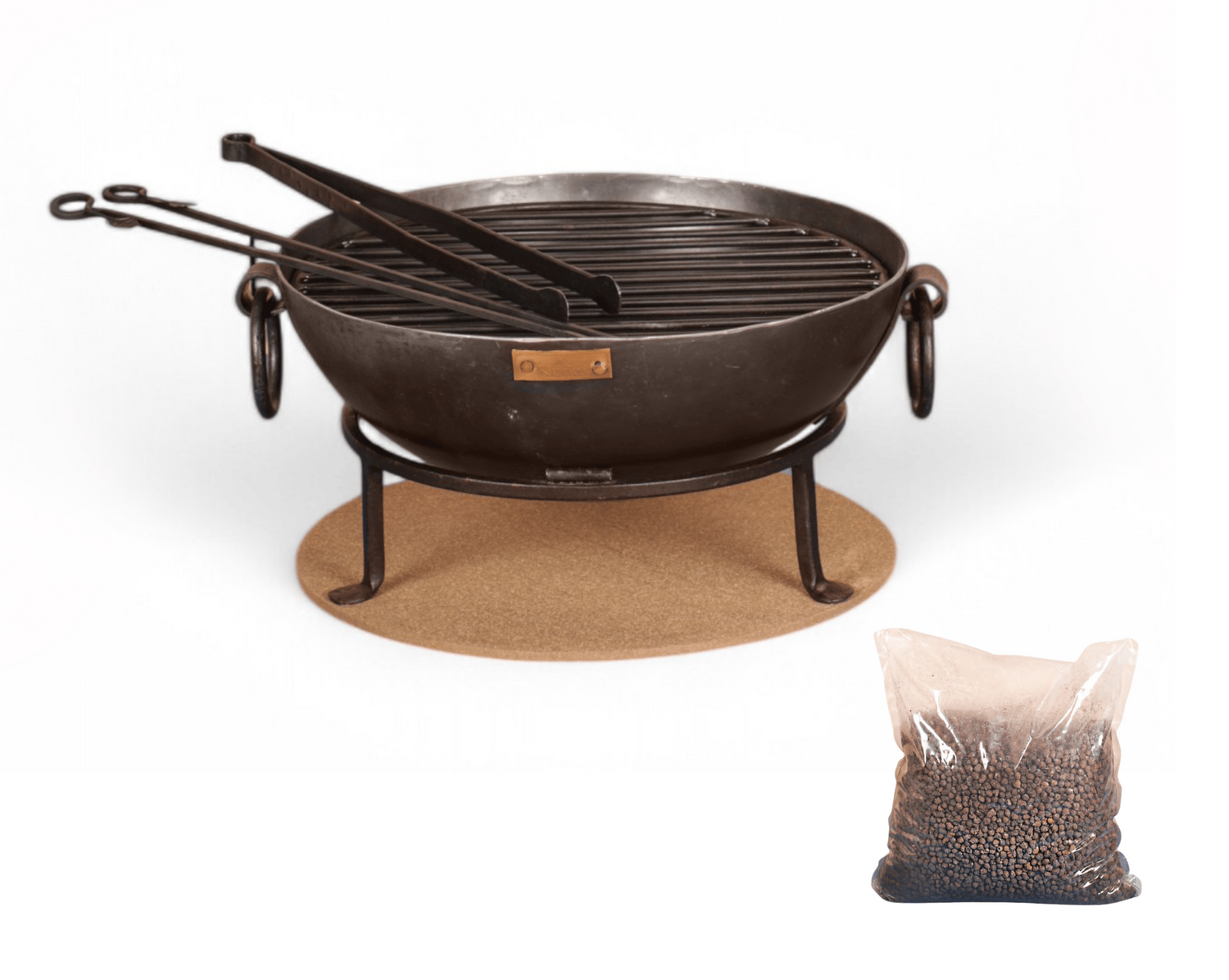 Black metal table fire pit with grill and tongs on a white background
