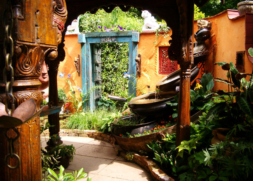 Ornate garden setting featuring a water fountain and wooden pillars.