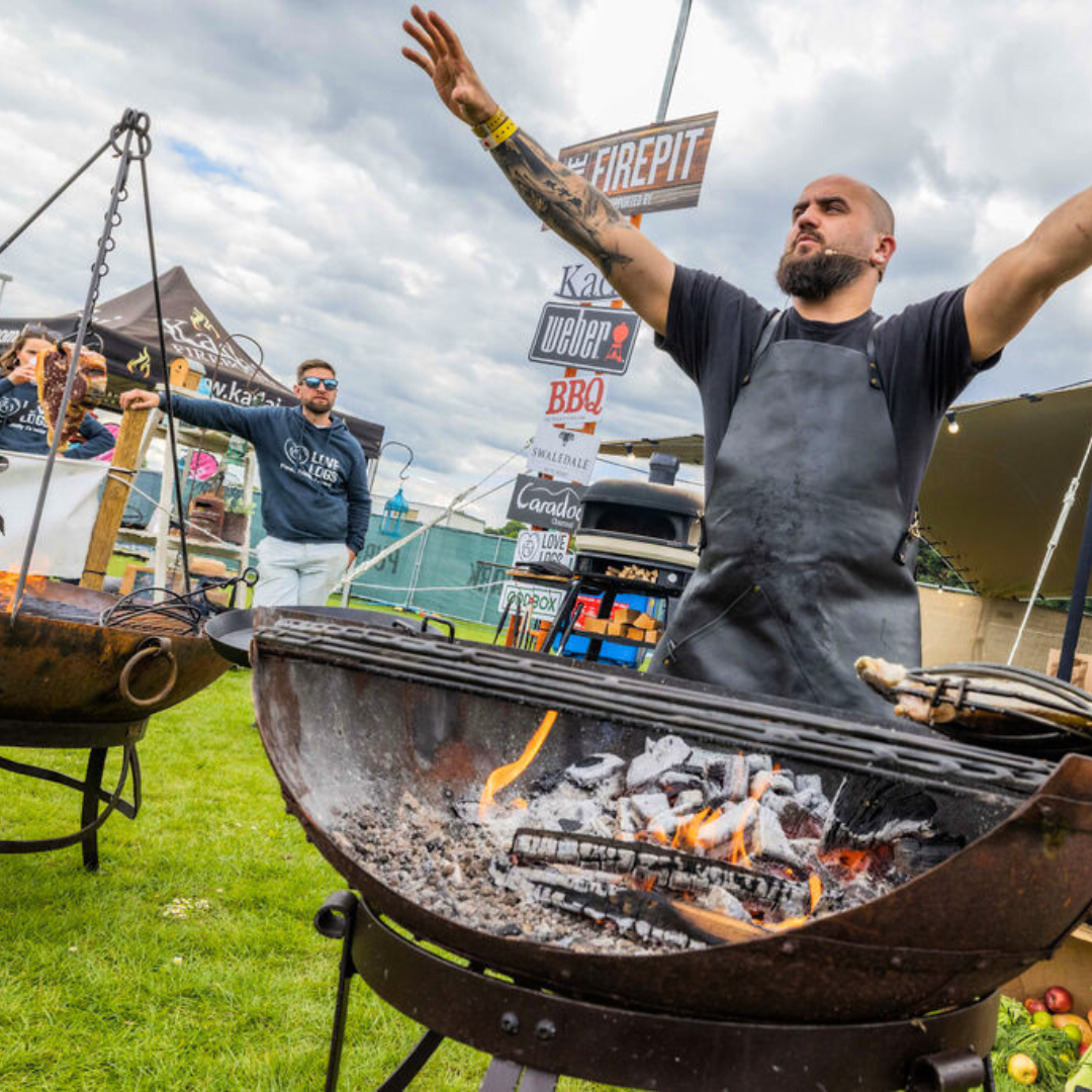 Man grilling outdoors on a kadai at pub in the park