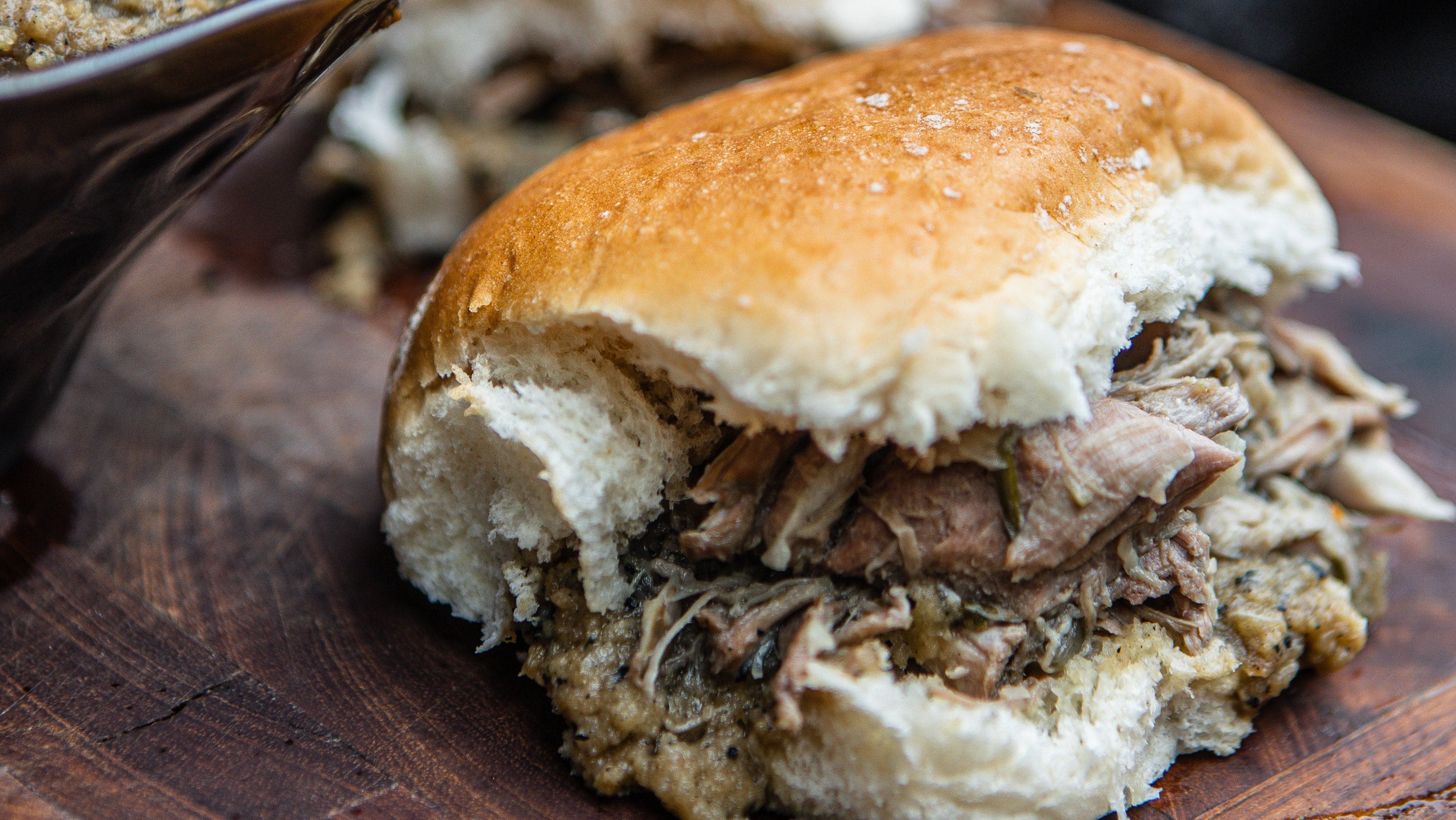 Two pulled pork sandwich on a wooden board