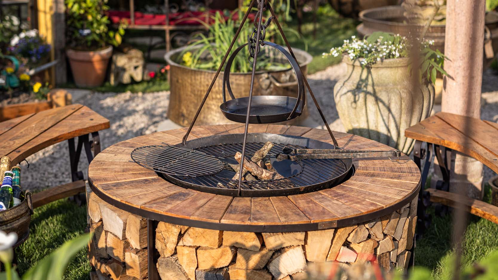 Outdoor garden setting with a kadai firebowl table and curved wooden benches.