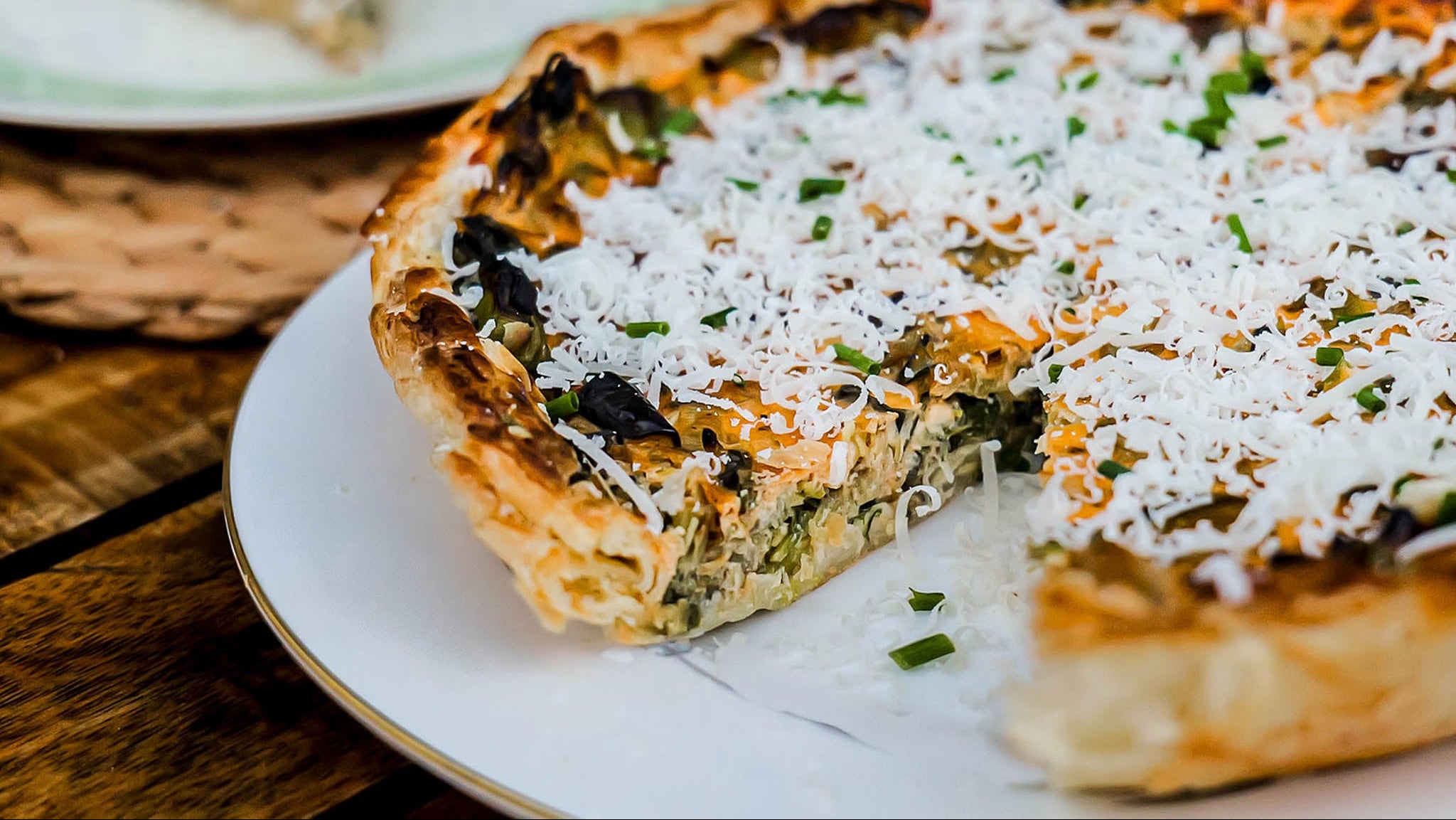 Pastry with white topping and green herbs on a plate