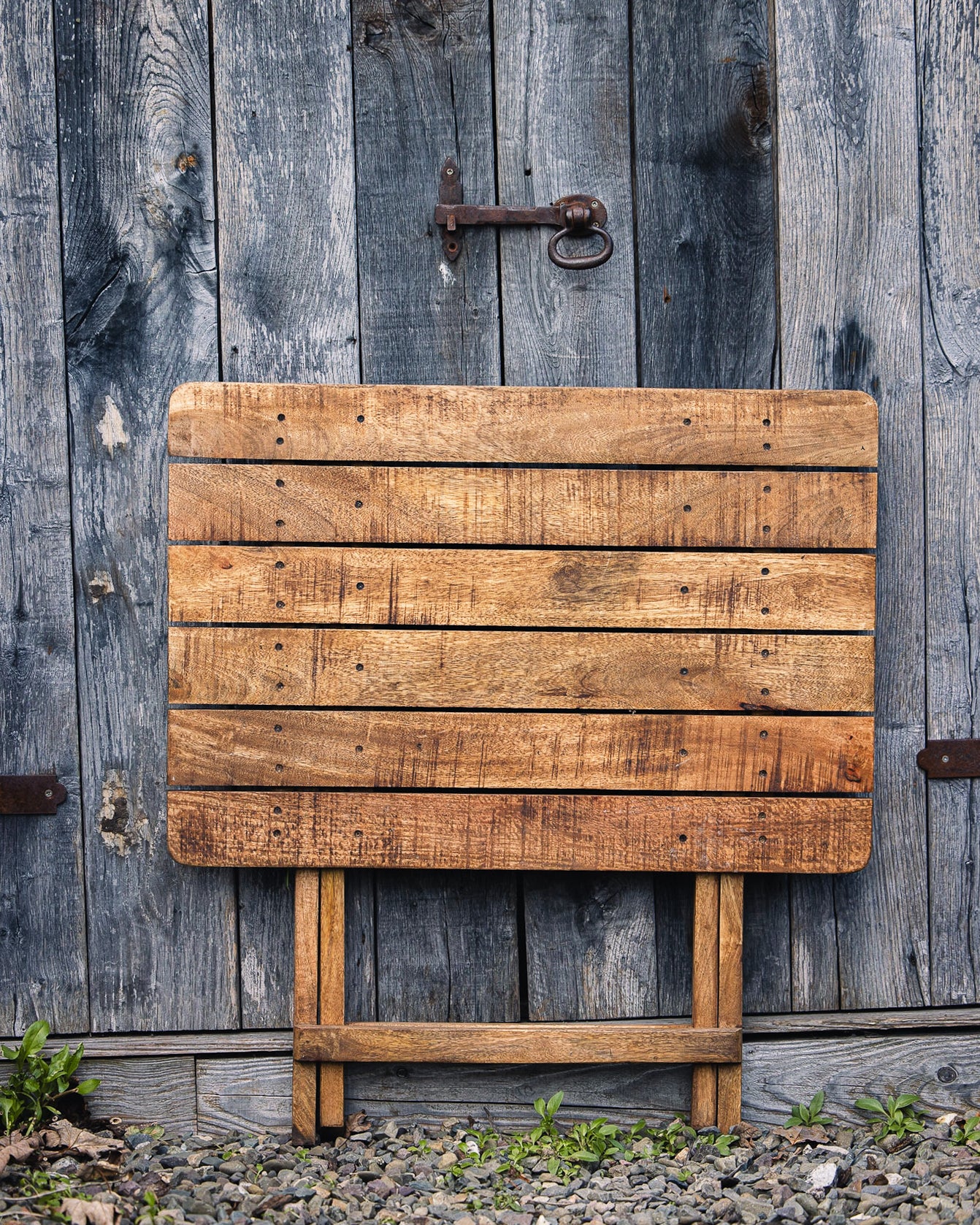 Compact handcrafted café table featuring natural wood grain and a classic folding design for outdoor spaces
