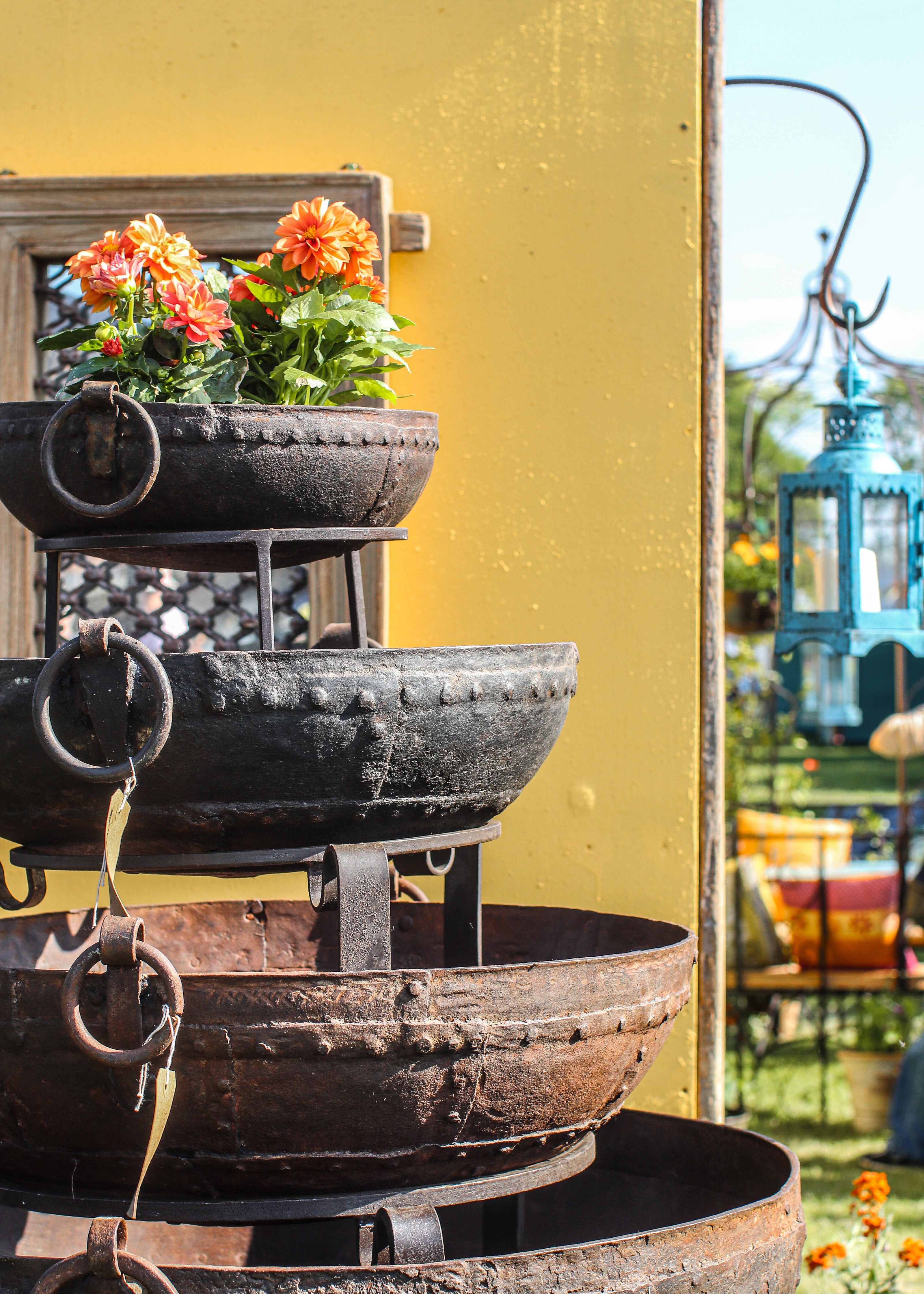 Decorative tiered Original Kadai with flowers against a yellow wall