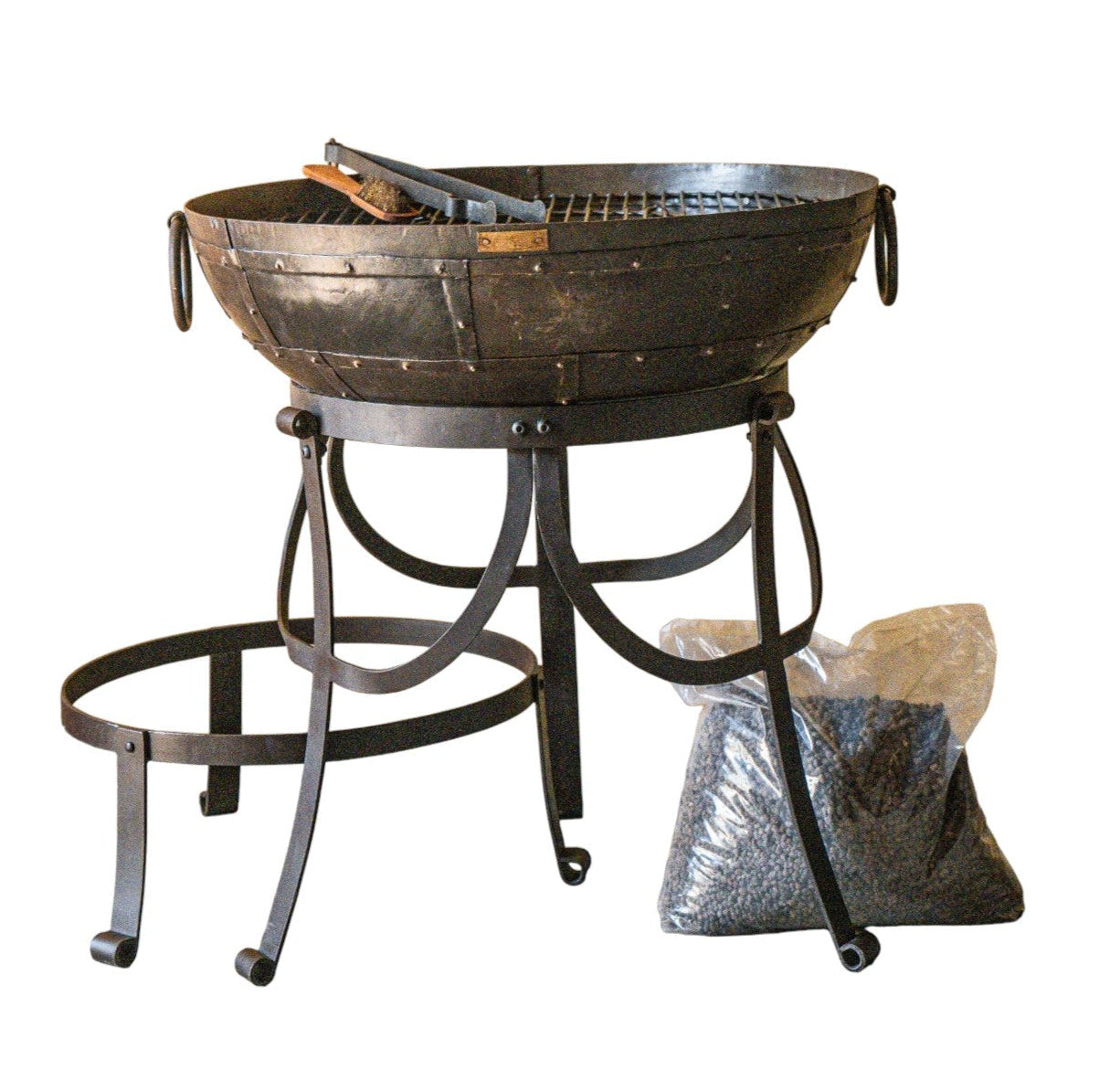 A round metal fire pit bowl with a matching stand, shown on a plain white background. 