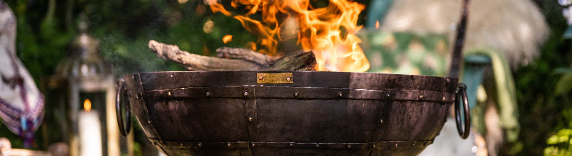 Kadai Fire pit with flames in a garden setting