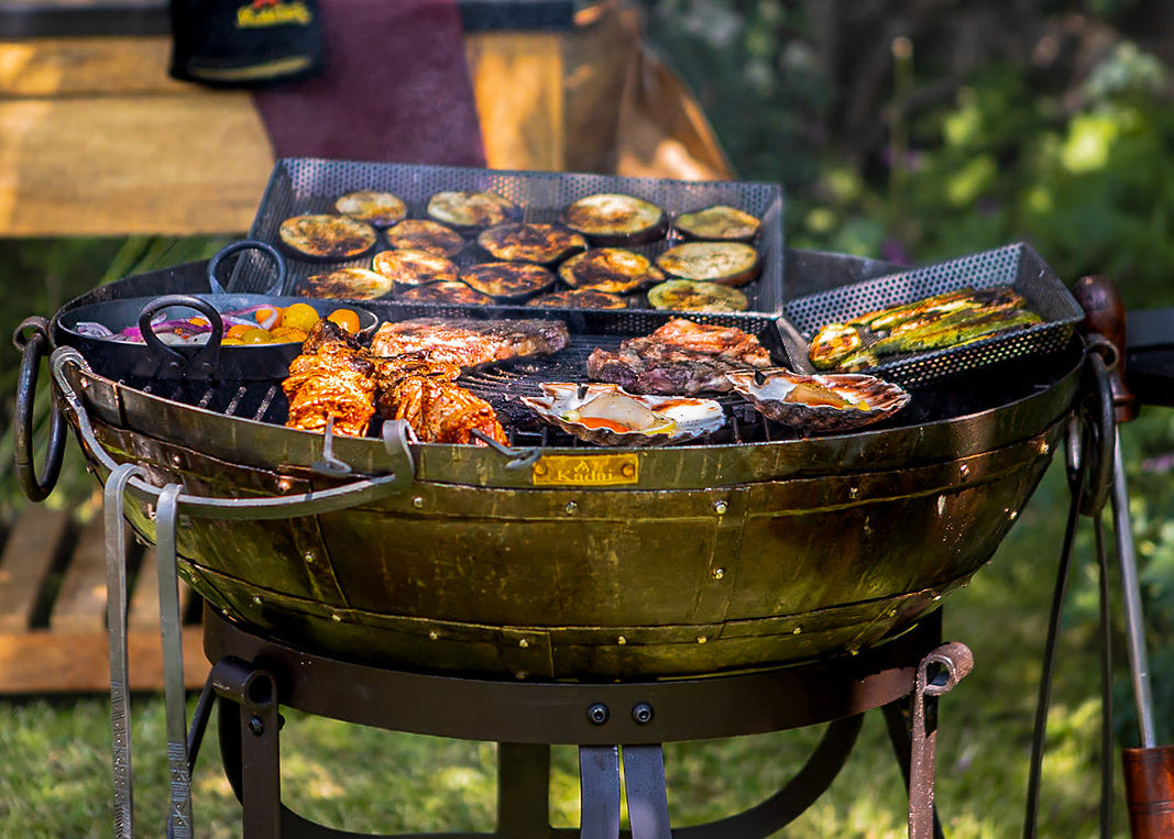 Barbecue grill with food on a grassy outdoor setting