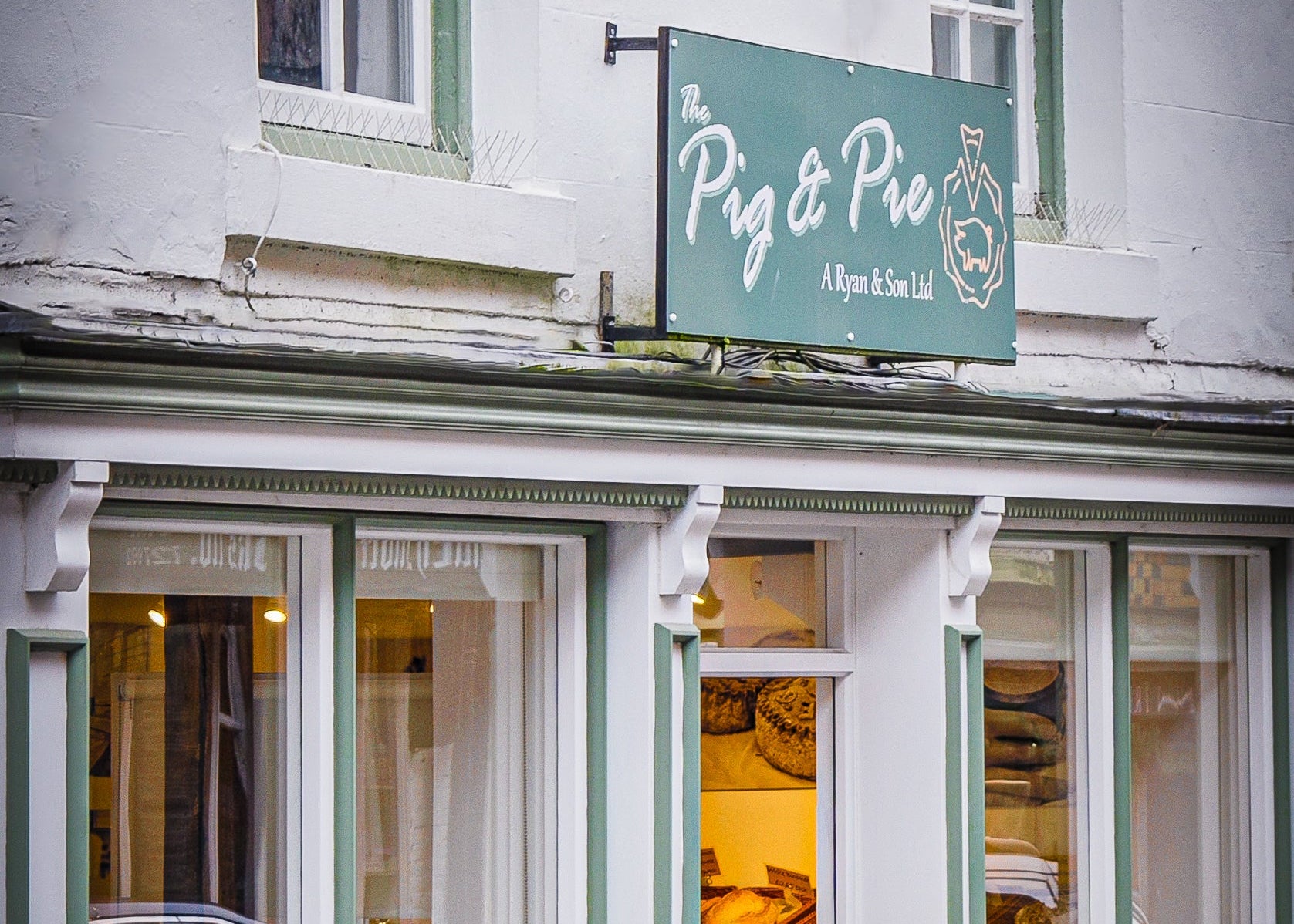 Sign for 'The Pig & Pie' restaurant above a building entrance.