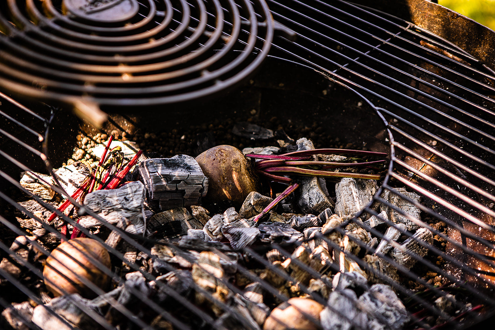 Close-up of a grill with charcoal and dirty cooking beetroot