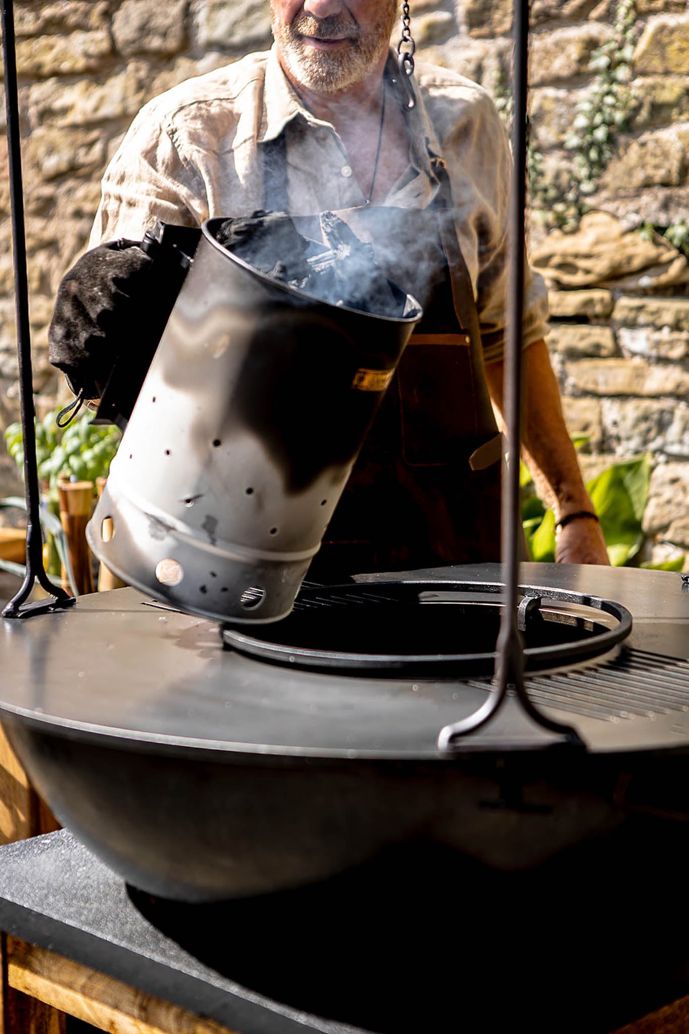 Barbecue grill with charcoal being poured in from Charcoal Starter