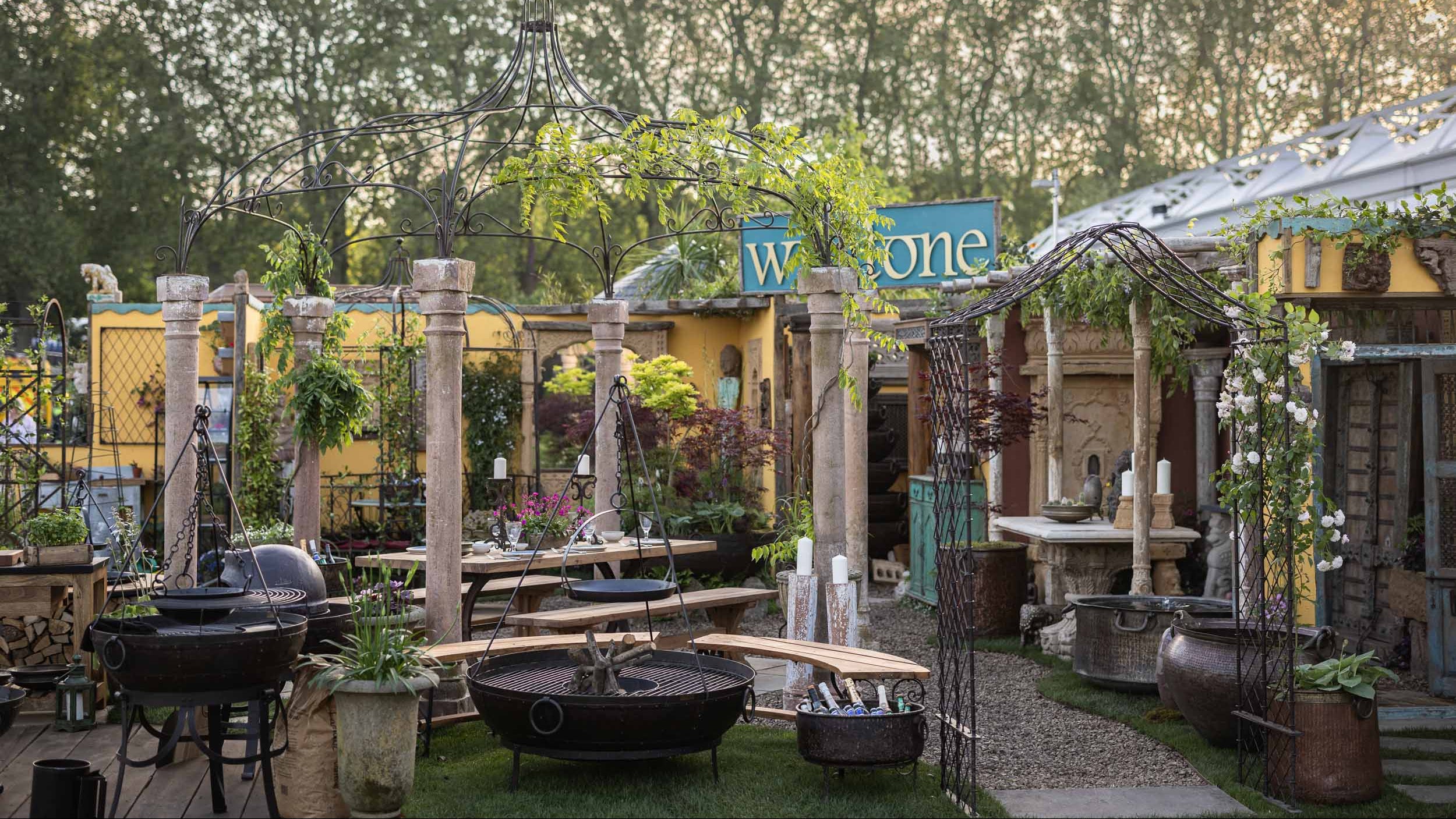 Outdoor garden setting with various plants, furniture, and decorative elements.