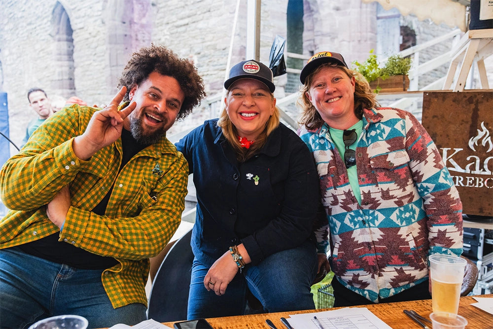 Three people posing together at a table with a casual setting