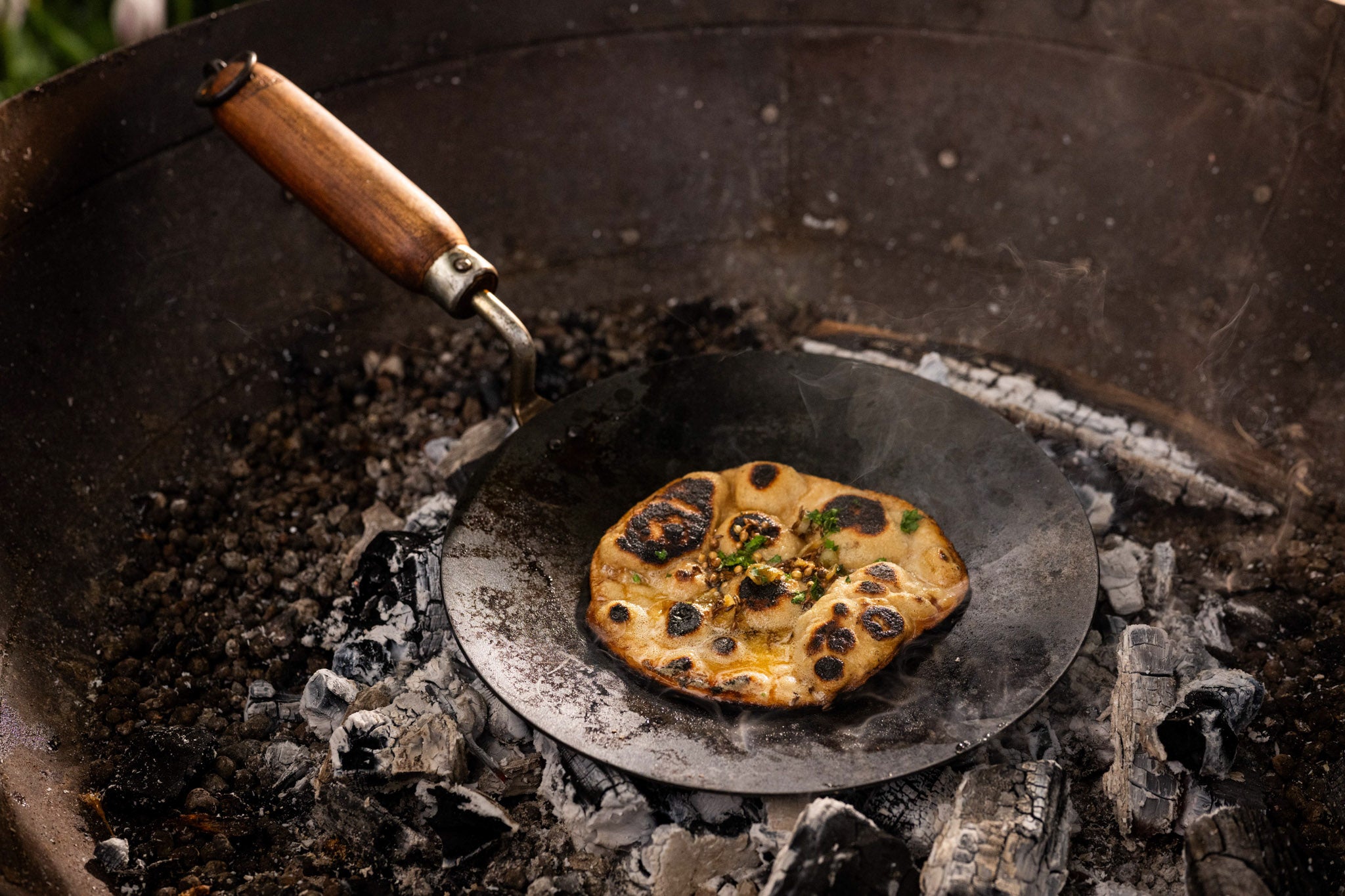 flatbread on chapati pan in kadai recycled firepit