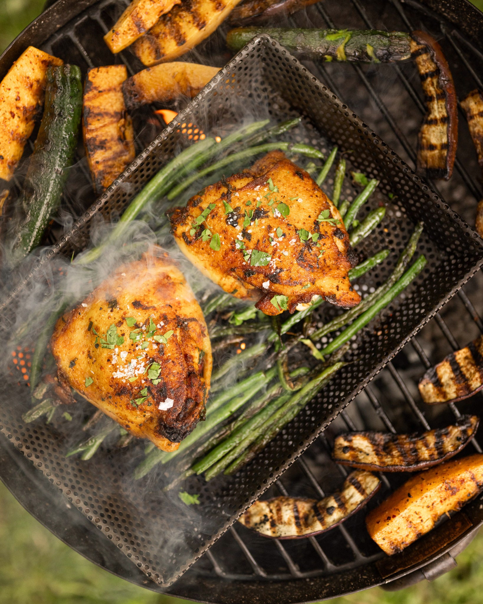 Cooking chicken and grilled vegetables on a portable bbq