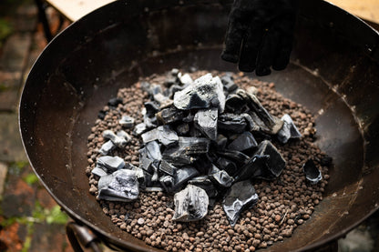 Hot charoal inside a round BBQ Ffire pit.